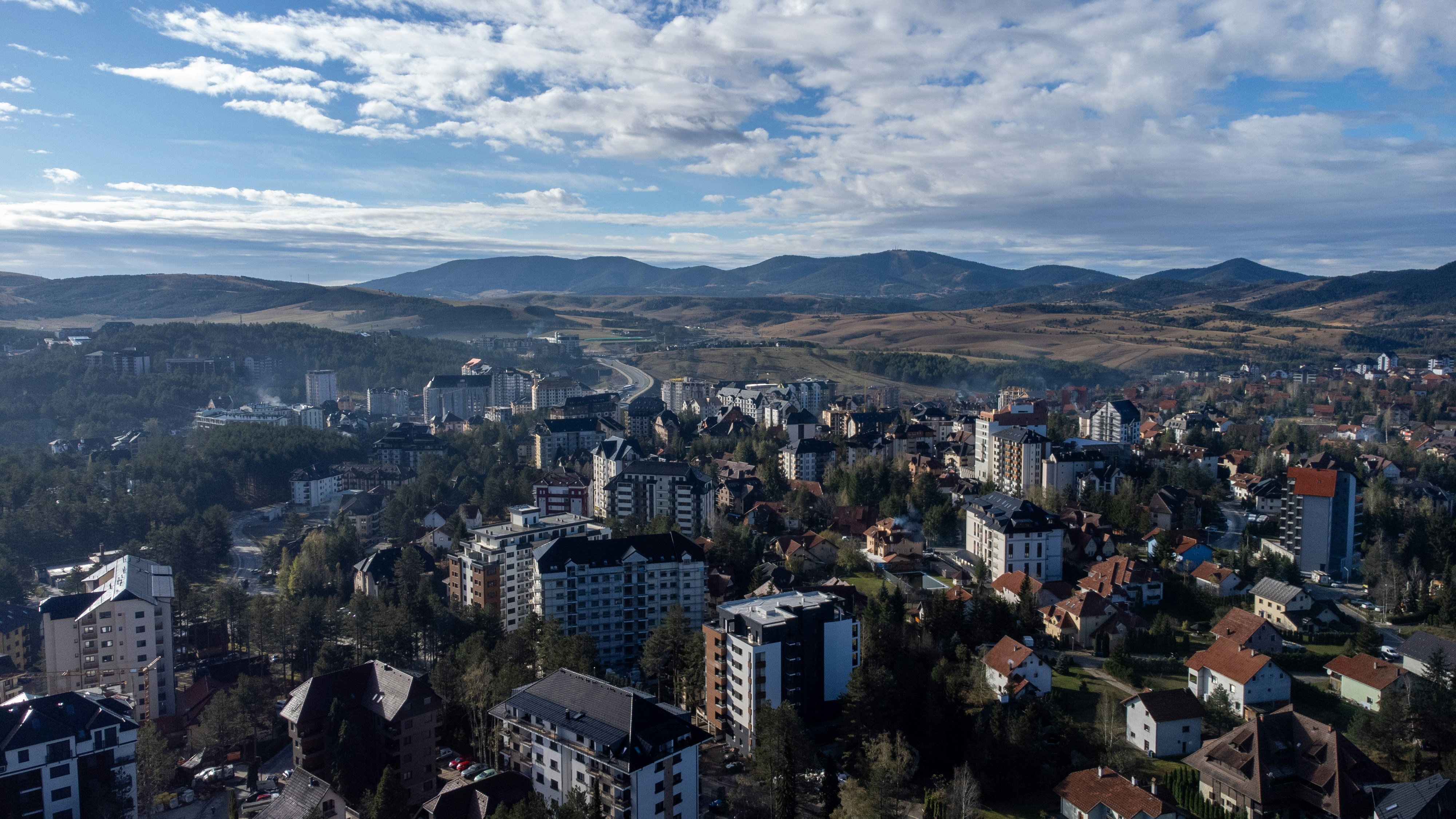 An aerial view of a city with mountains in the background
