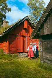 A group of people standing in front of a wooden cabin