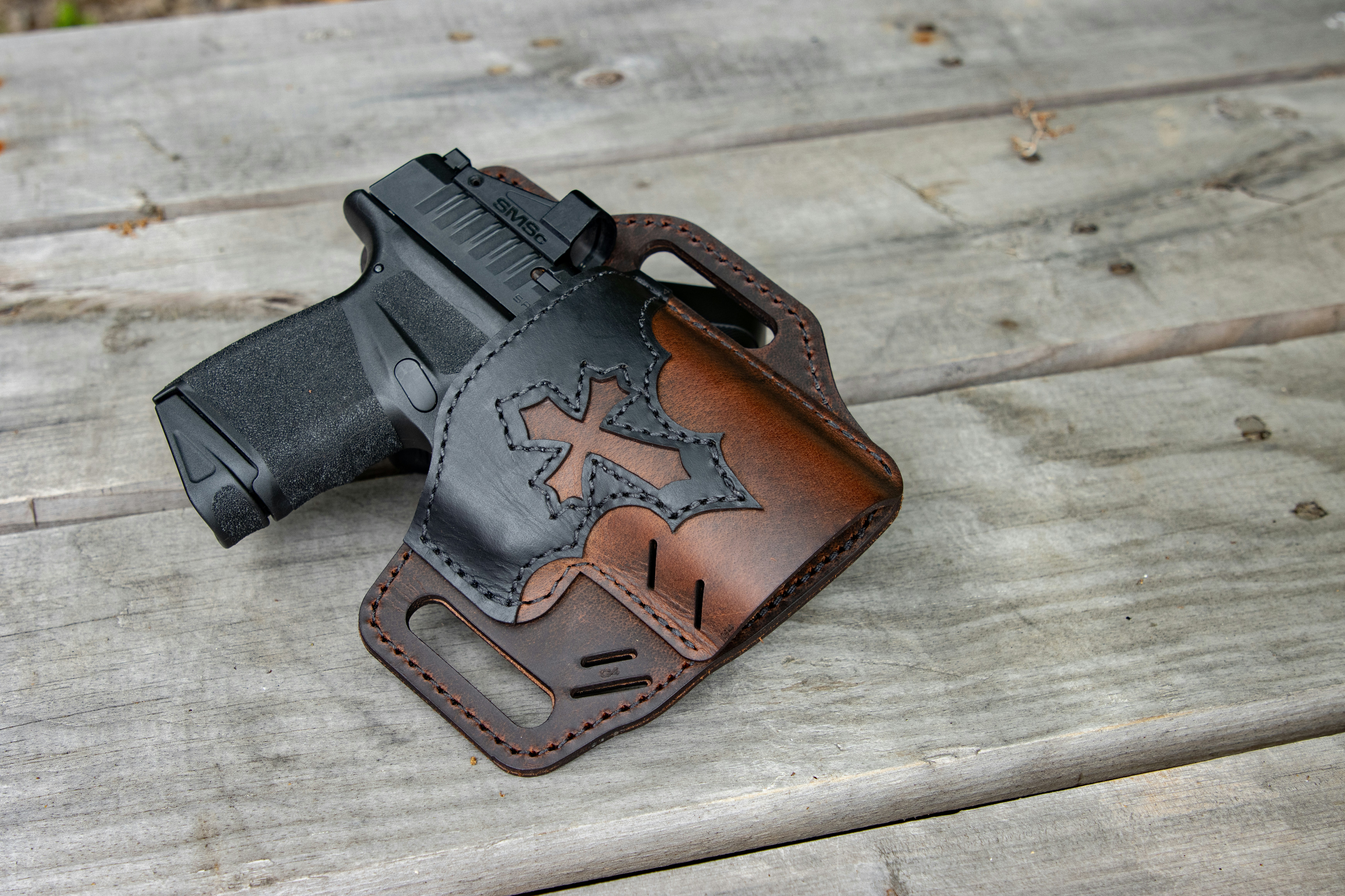 A leather holster with a gun on a wooden table