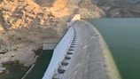 A large body of water next to a mountain