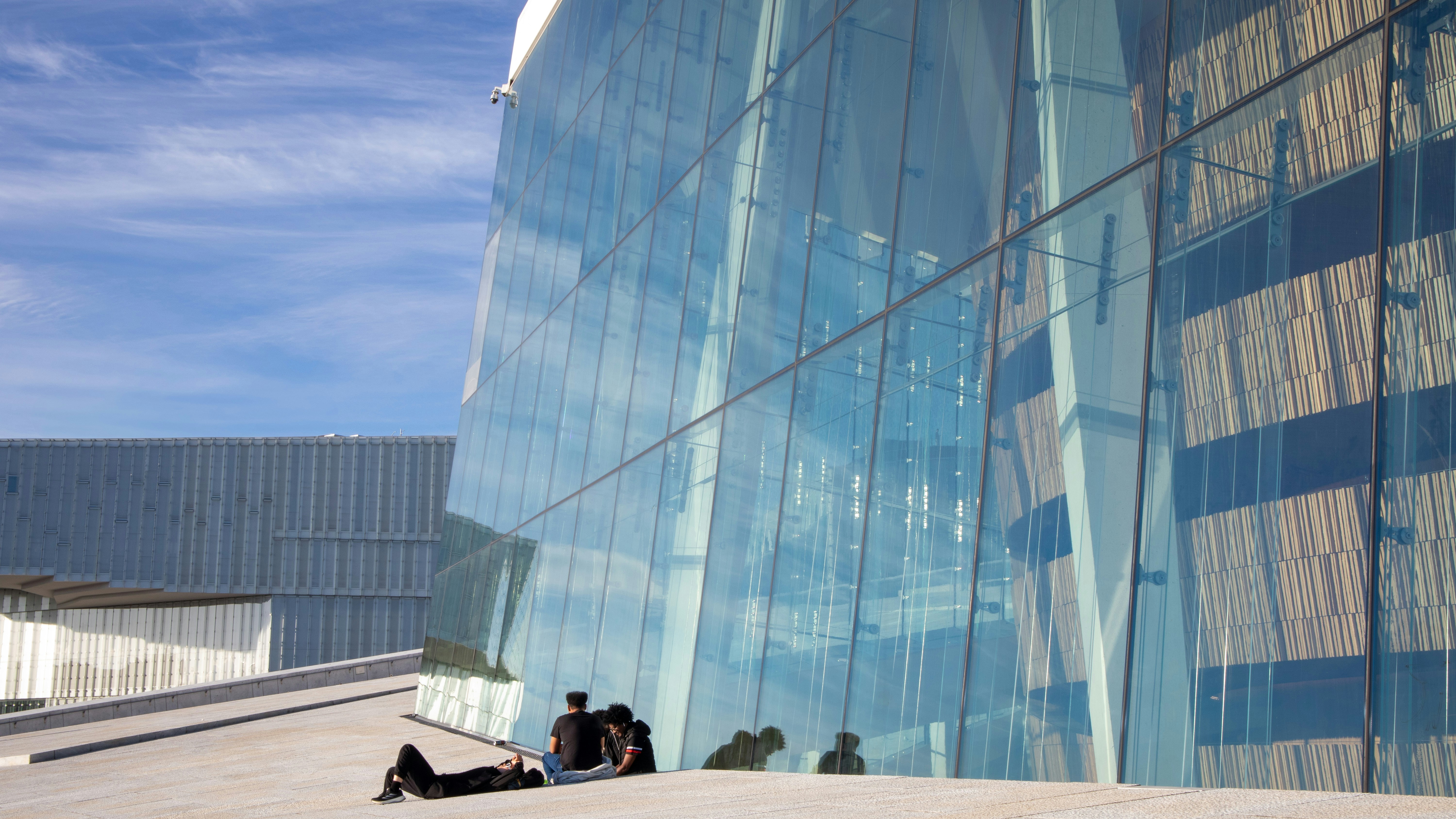 Un groupe de personnes assises à l’extérieur d’un grand bâtiment
