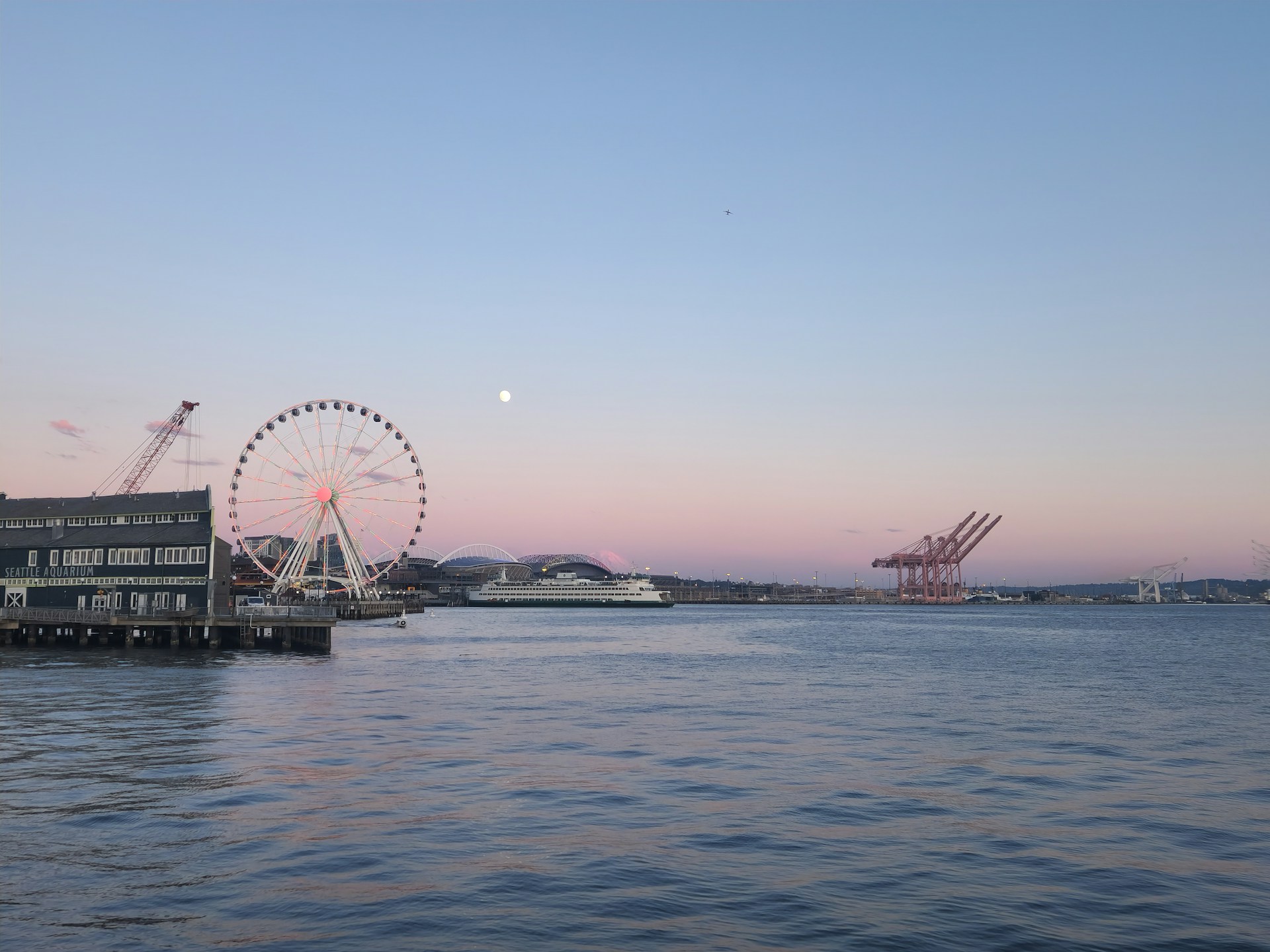 A ferris wheel sitting on top of a pier next to a body of water