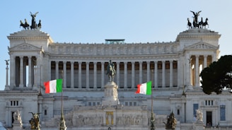 A large white building with flags flying in front of it