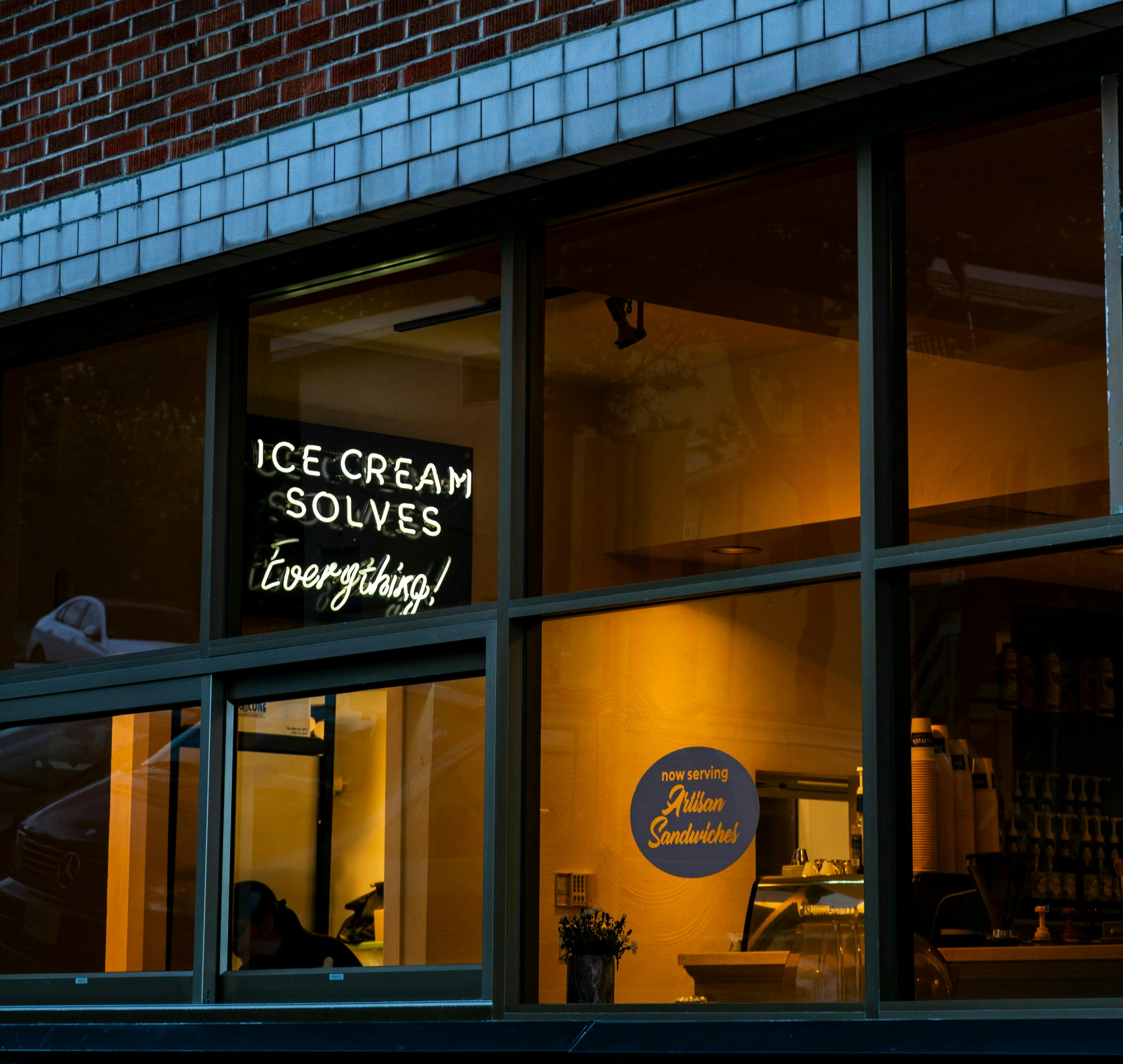 An ice cream shop is lit up at night