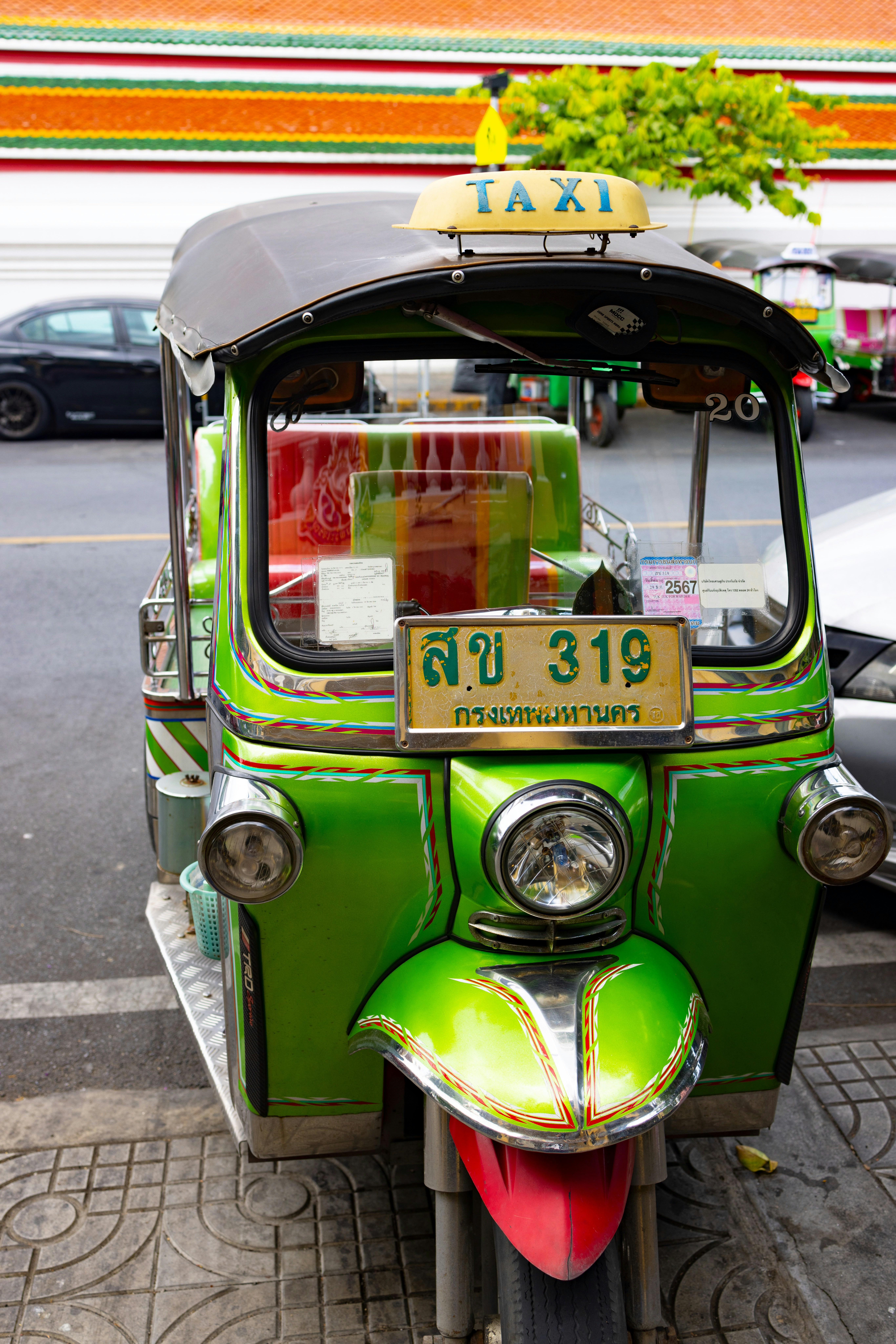A green and white scooter parked on the side of the road