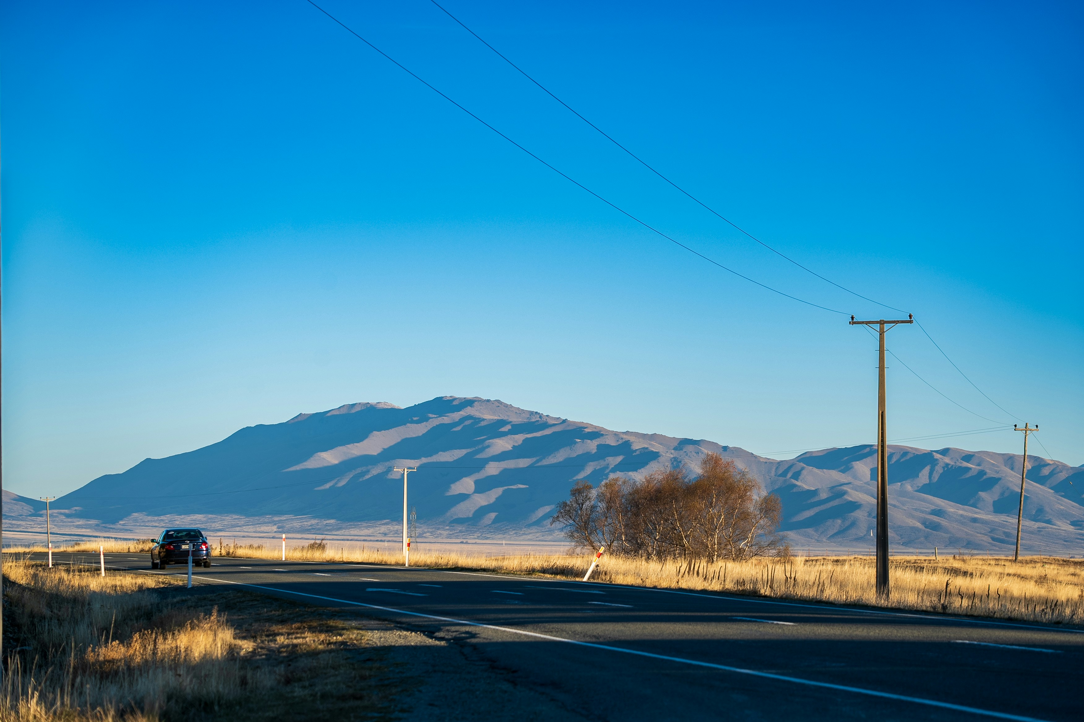 Ein Lastwagen, der mitten in der Wüste eine Straße entlangfährt