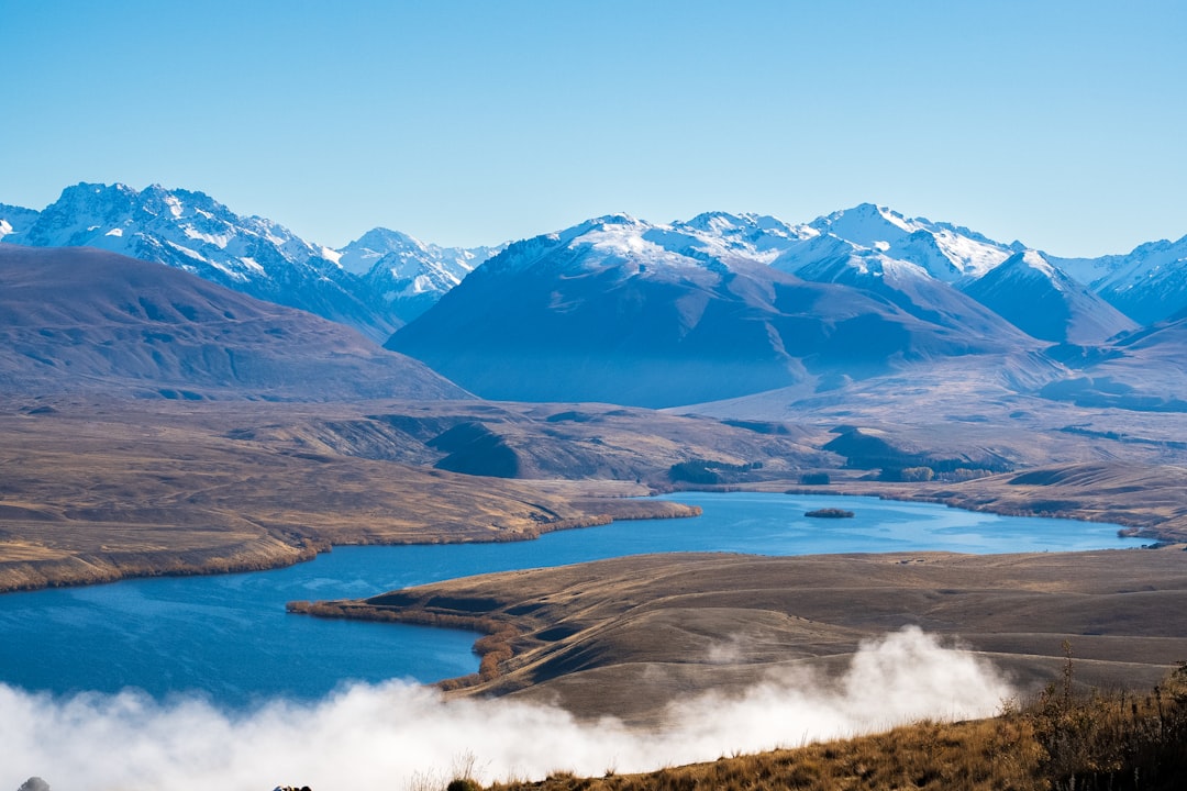 A scenic view of a mountain range with a lake in the foreground,
