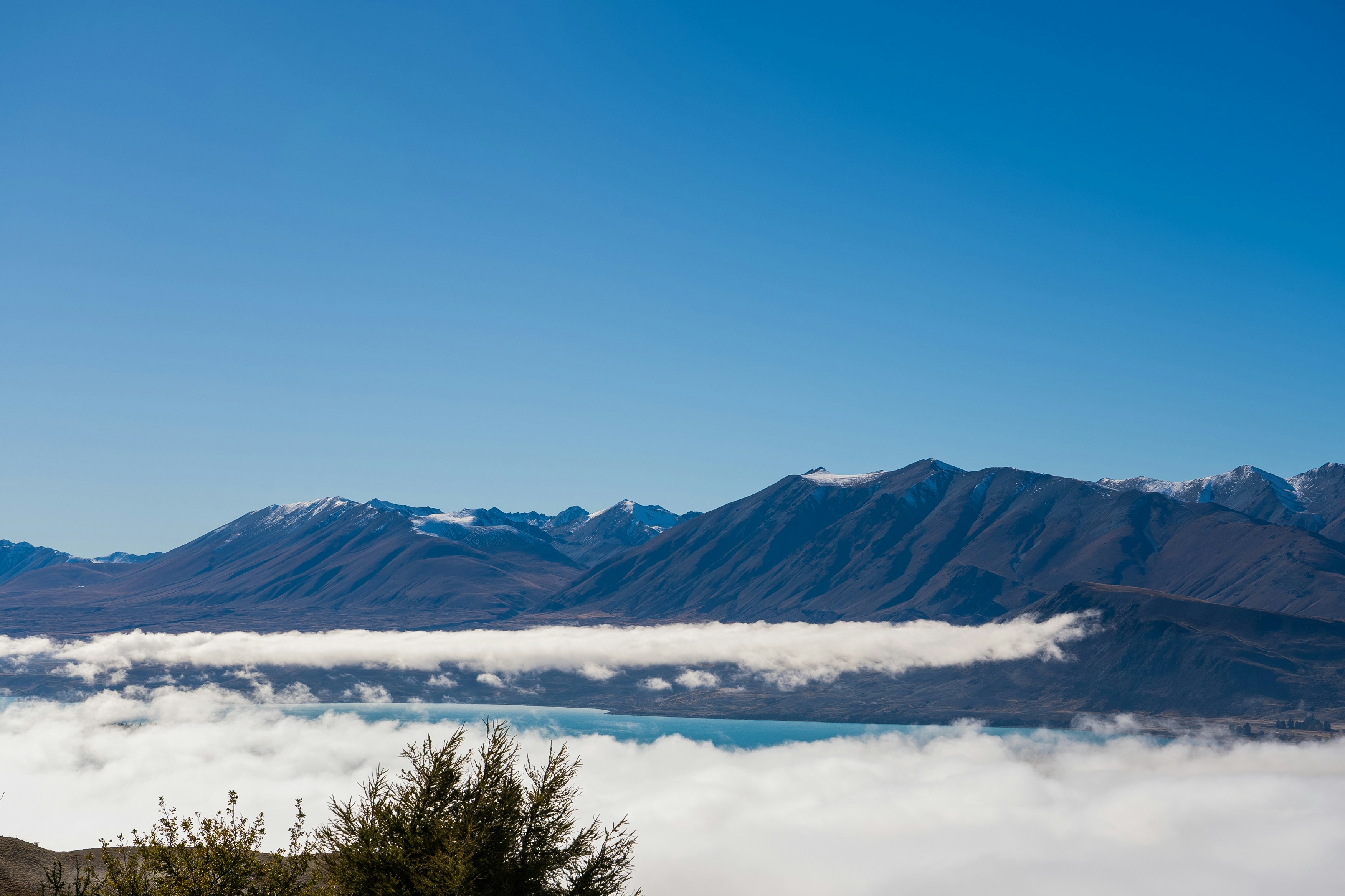 A view of a mountain range with clouds and mountains in the background, 