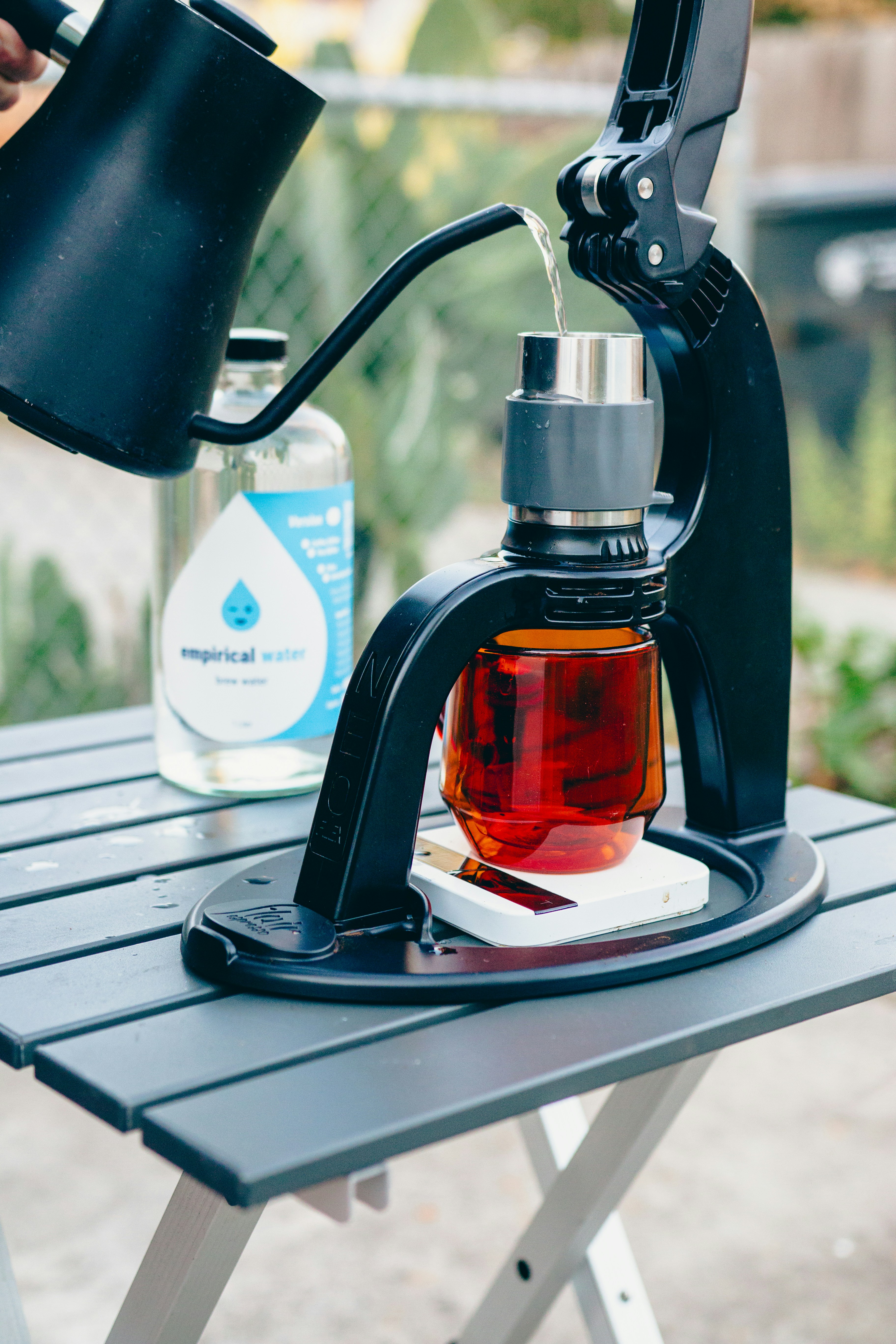 A person pours tea from a teapot into a cup