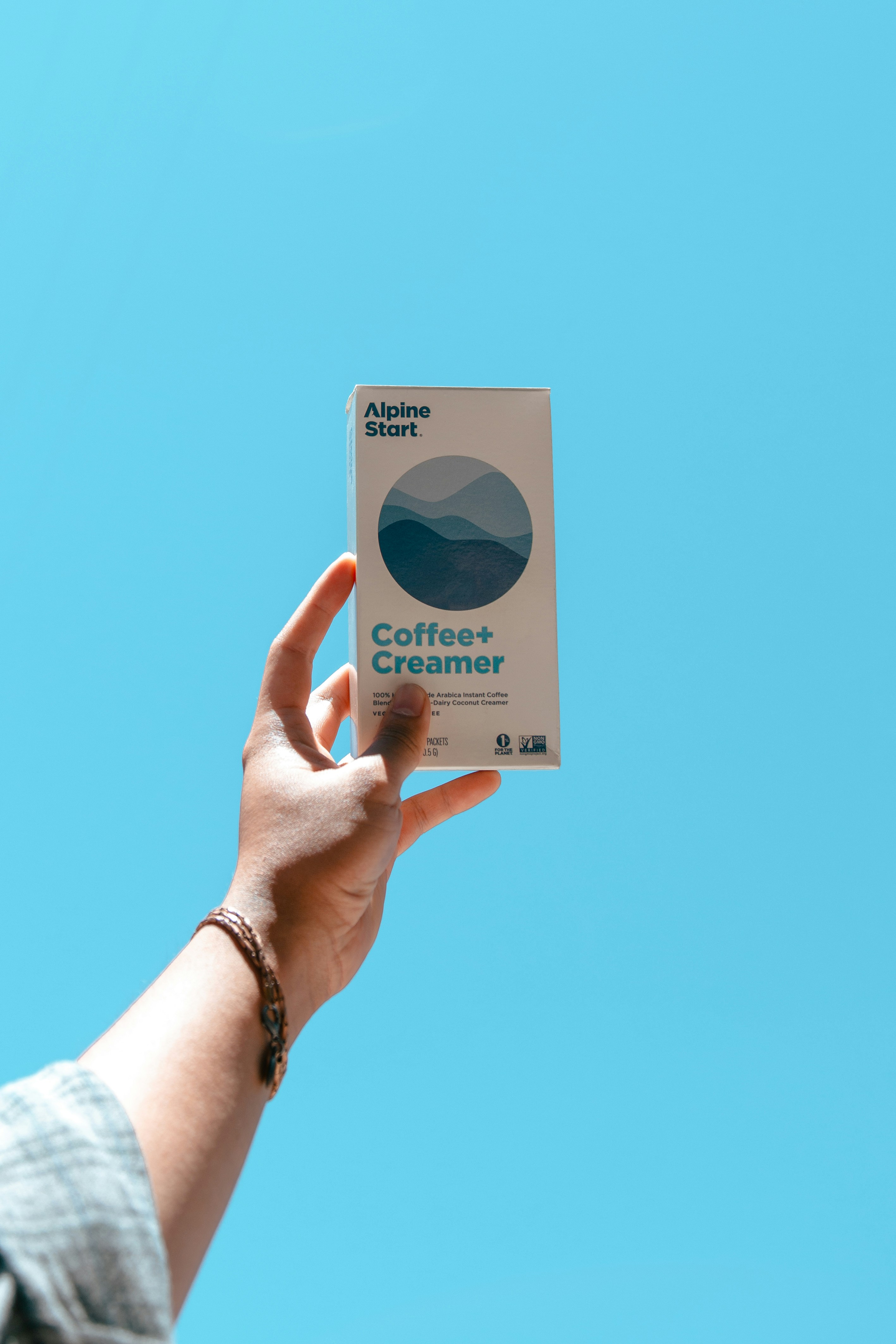 A person holding up a box of coffee