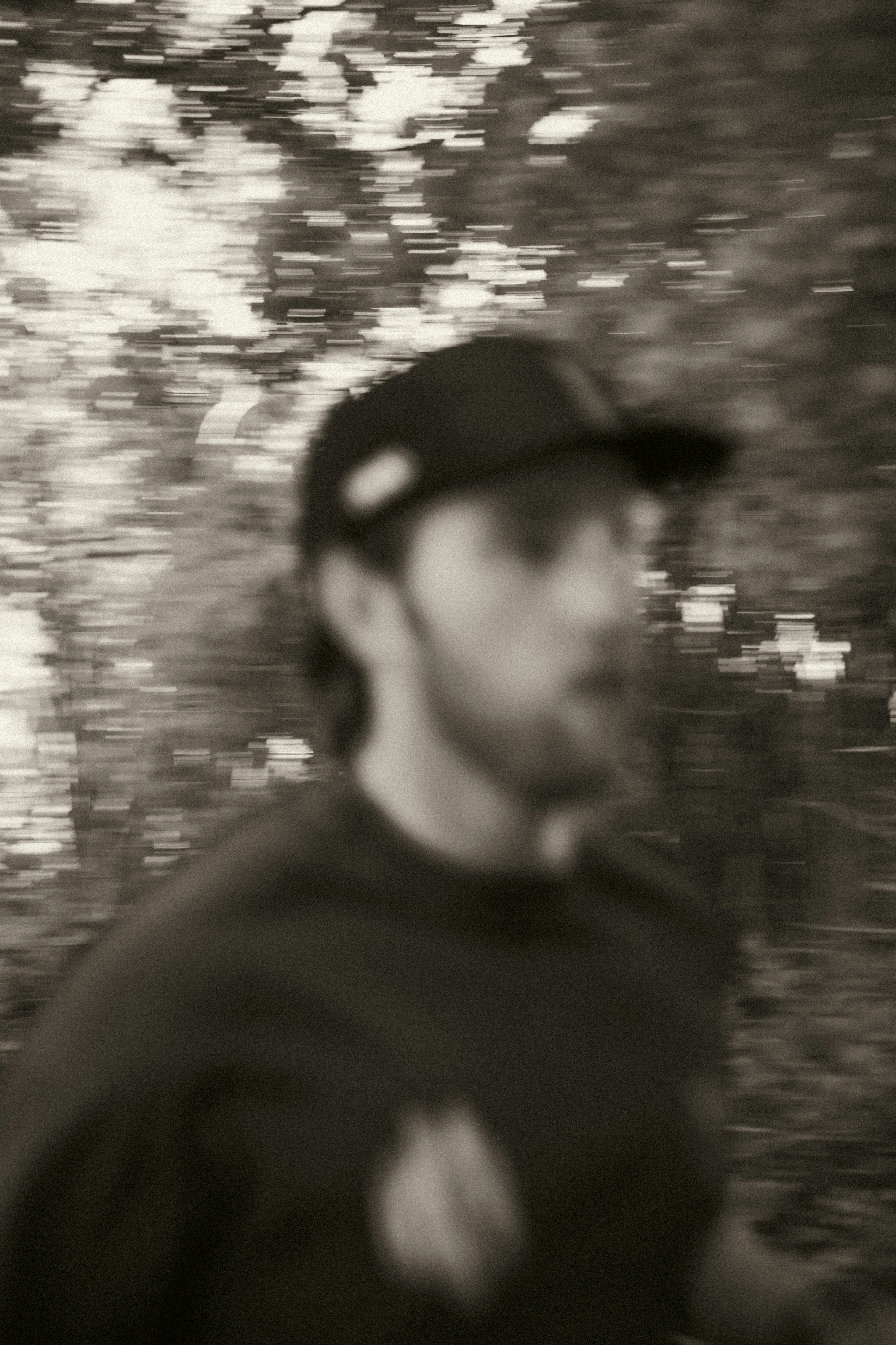 A man in a baseball cap is walking in the woods