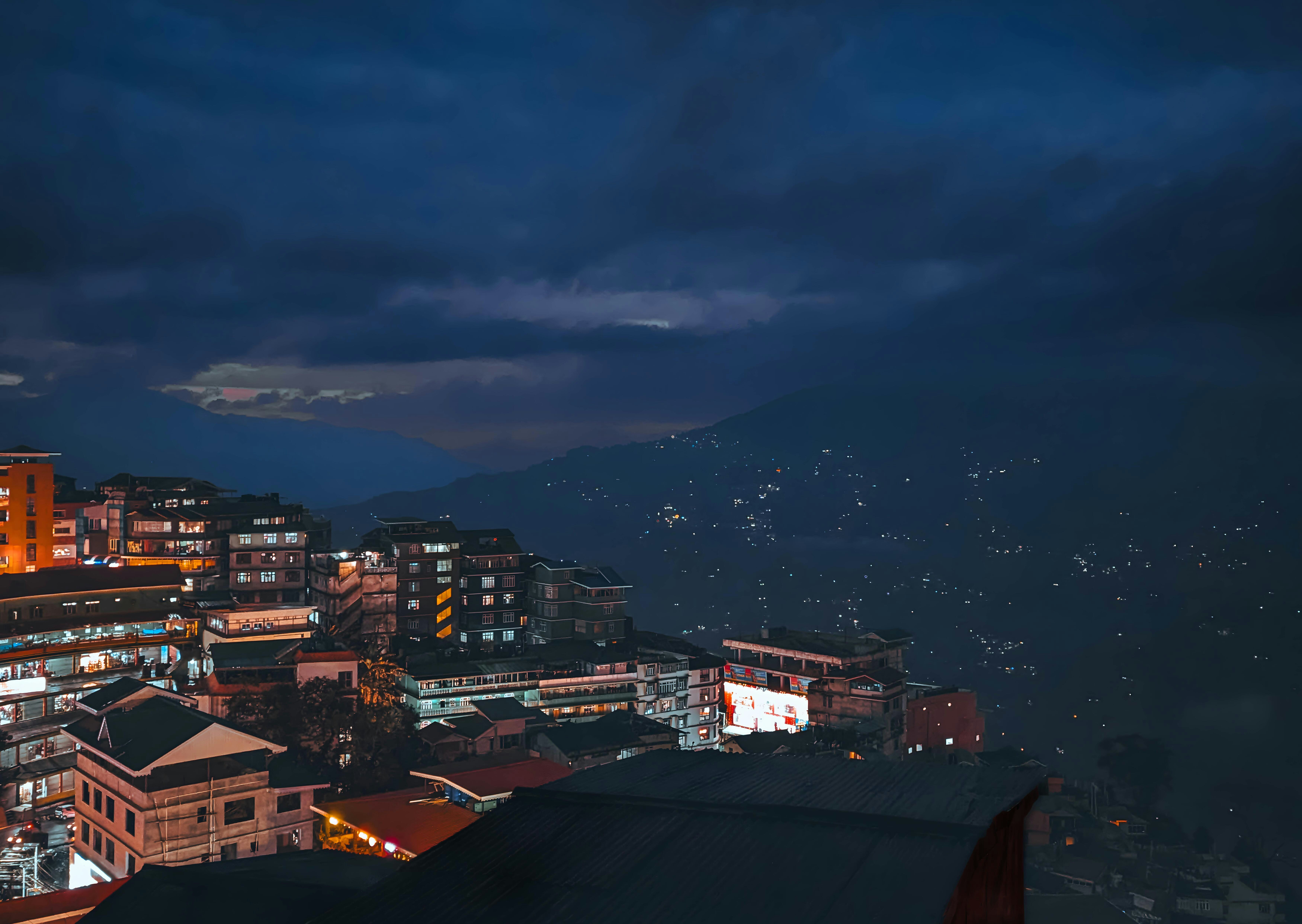 A view of a city at night from the top of a hill