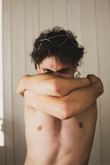 A shirtless man with his arms crossed
