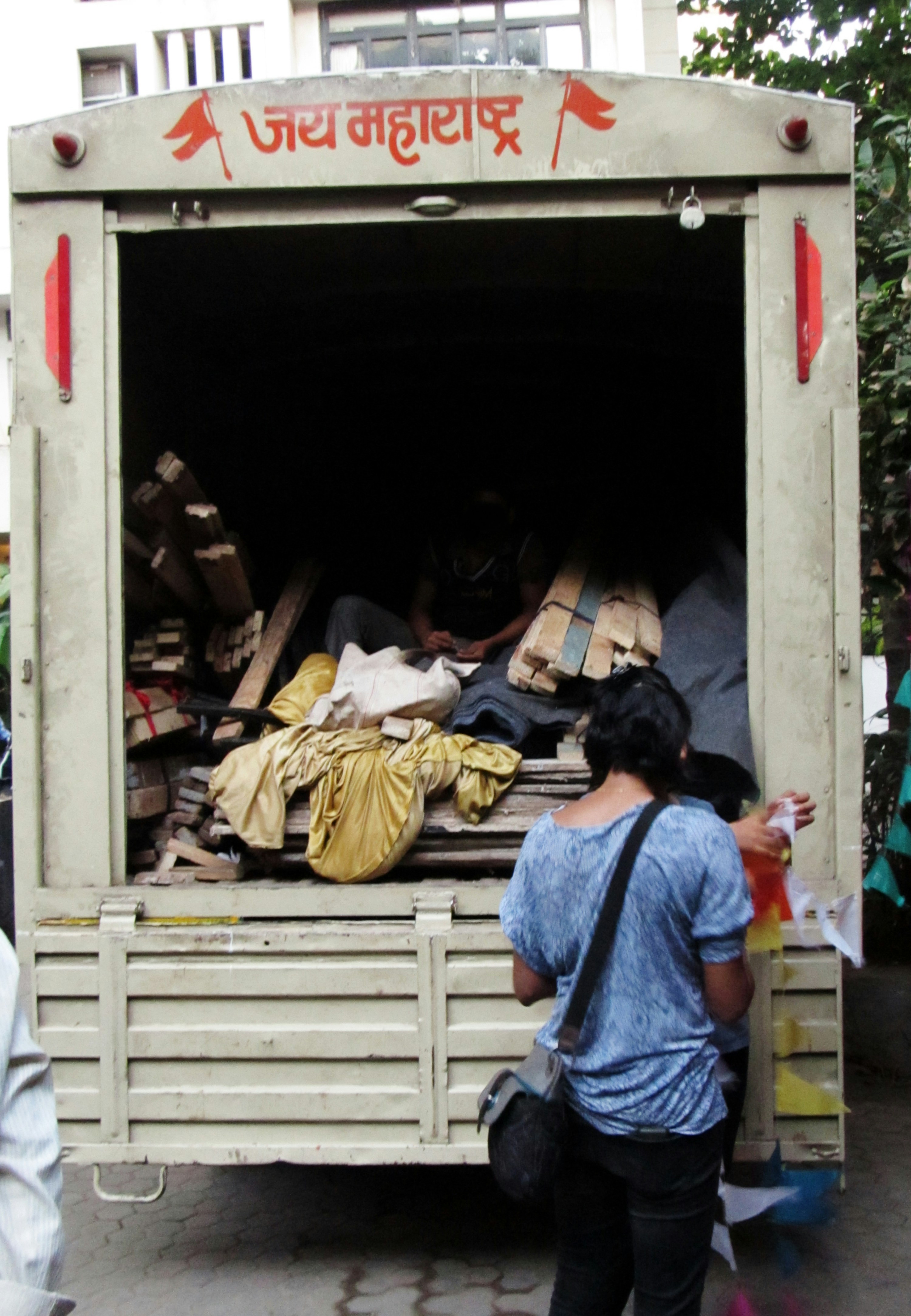 A woman standing in front of a truck filled with items