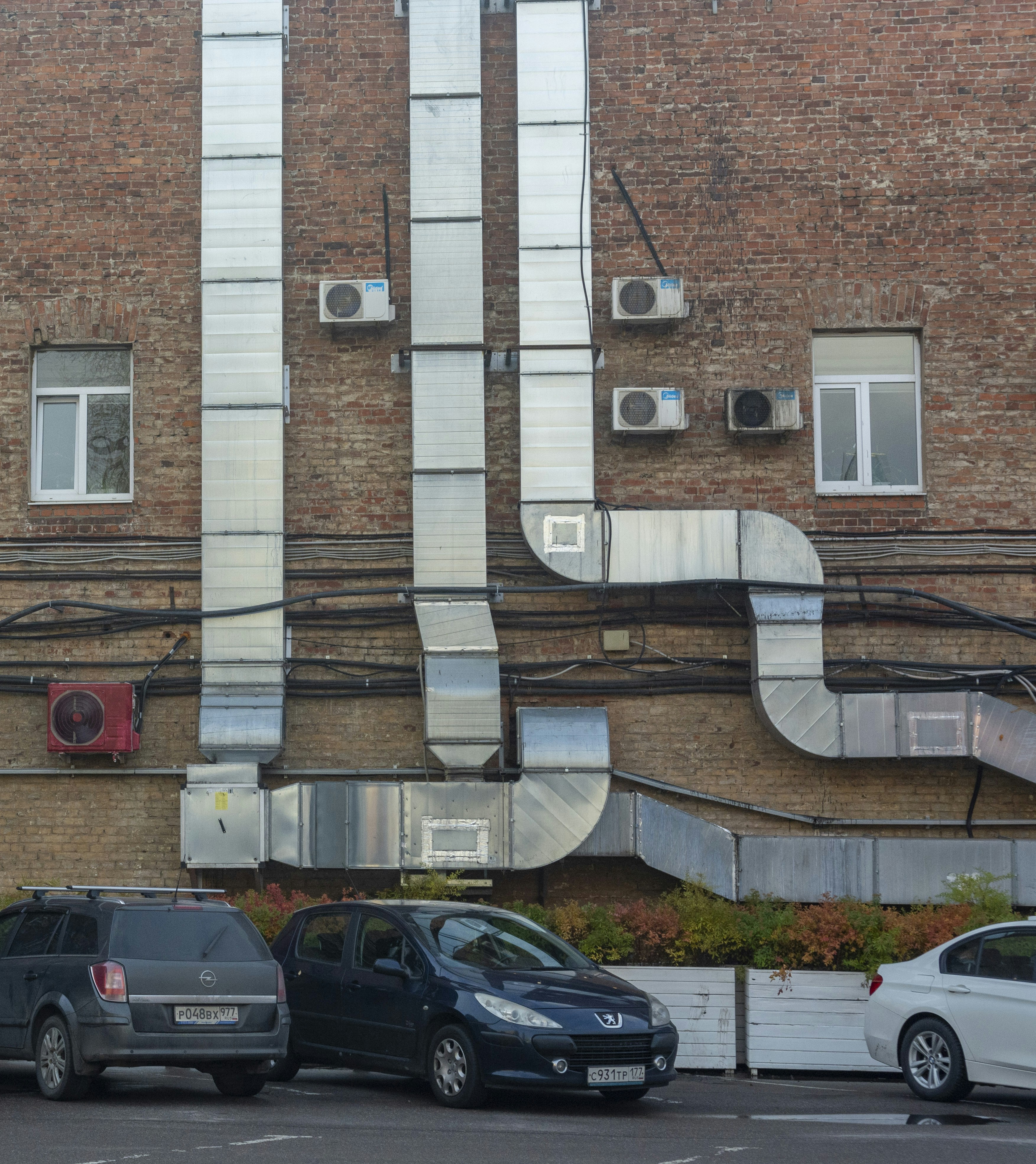 A building with a lot of windows and a lot of cars parked in front of