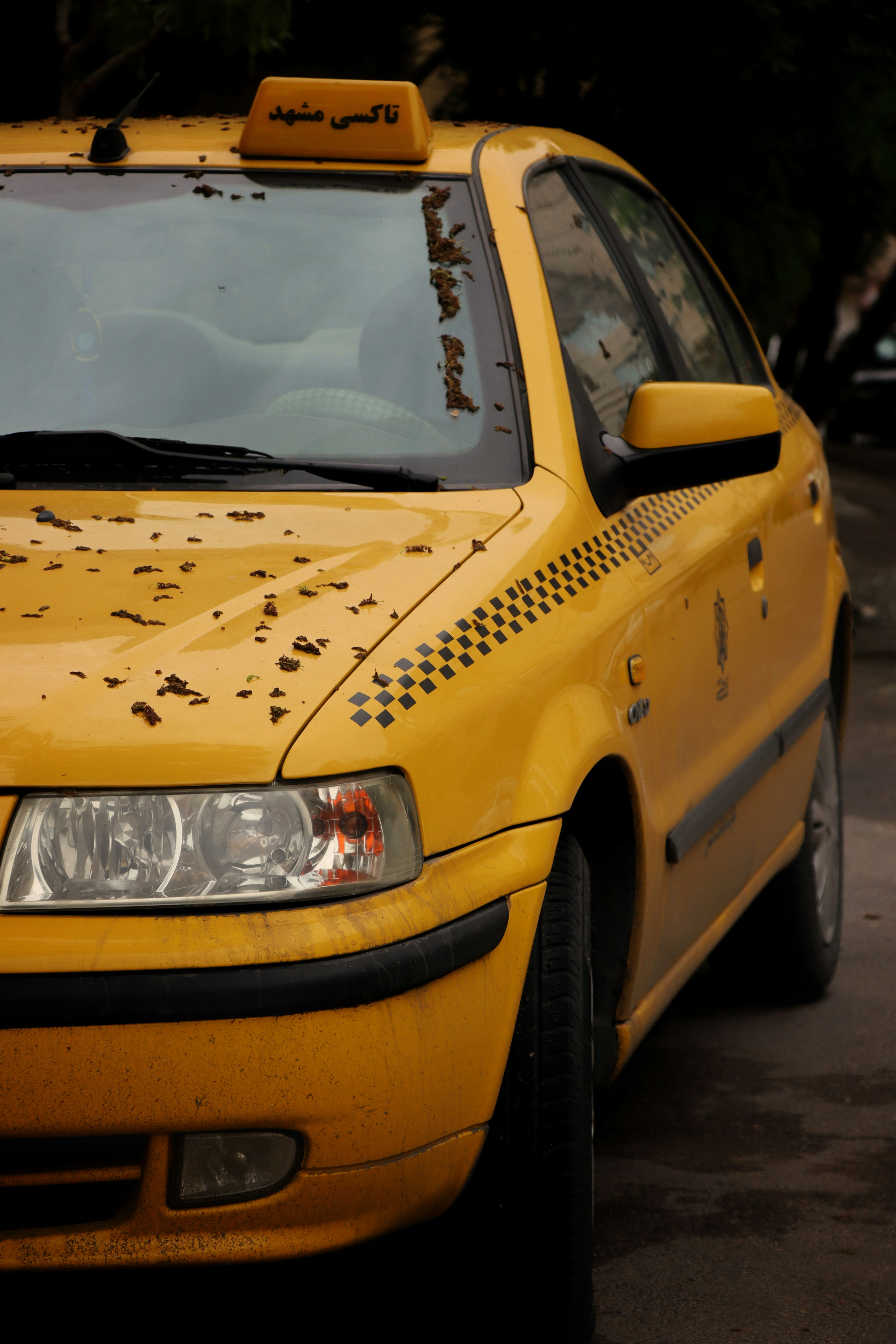 A yellow taxi cab parked on the side of the road