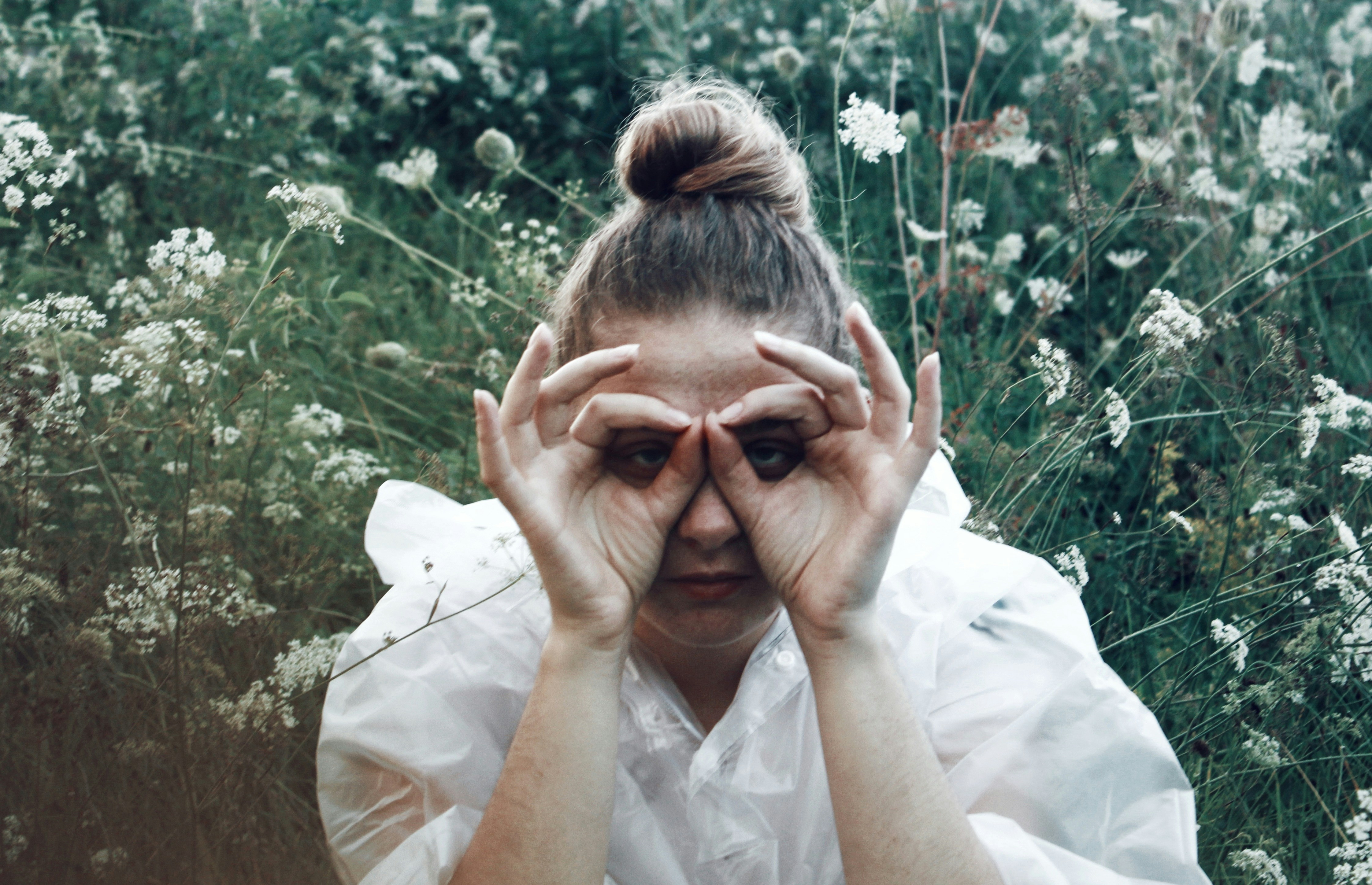 A woman in a white dress holding her hands to her face