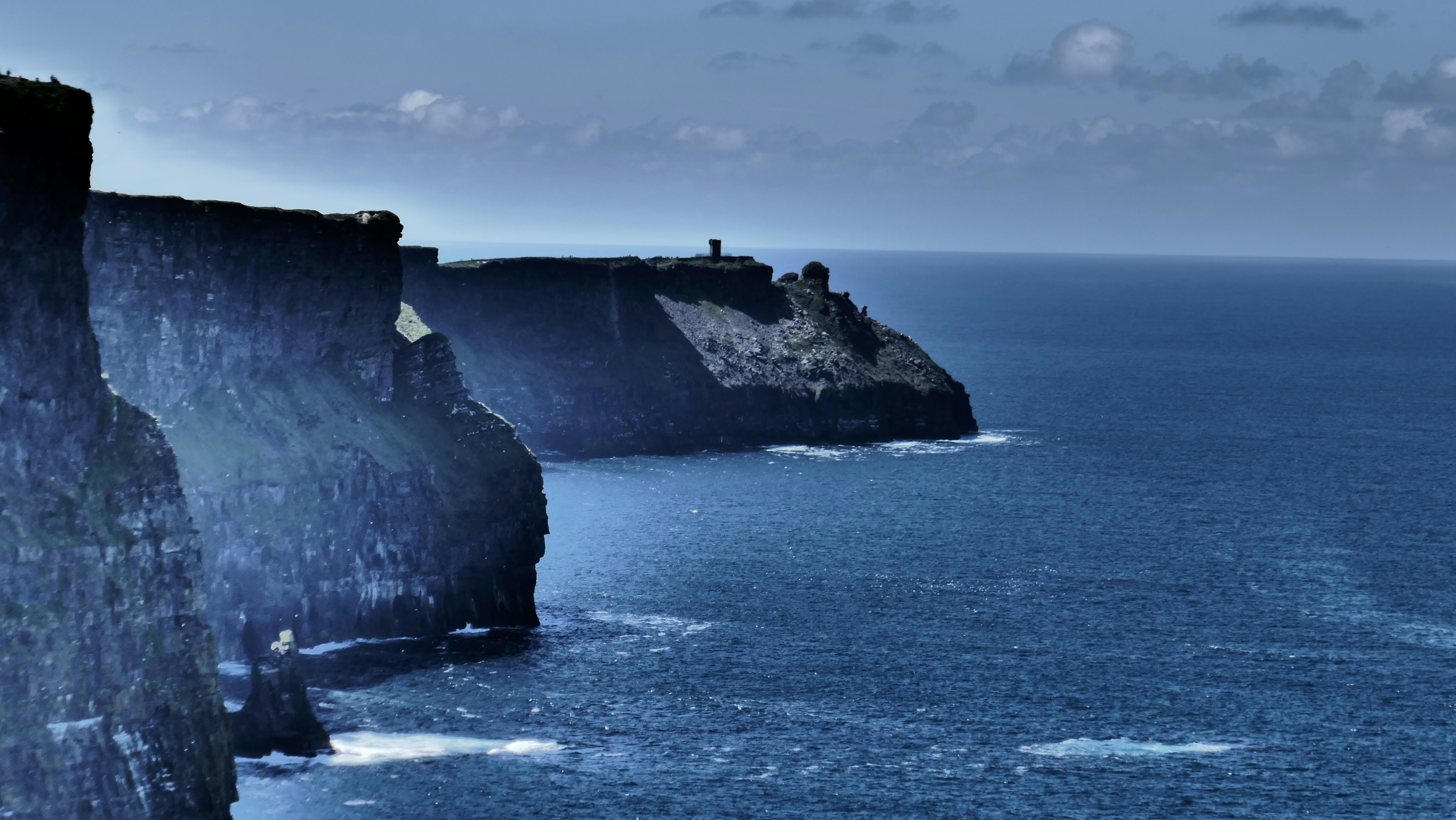 A group of cliffs sitting on the side of a large body of water