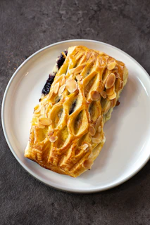 A white plate topped with a pastry on top of a table