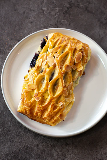 A white plate topped with a pastry on top of a table