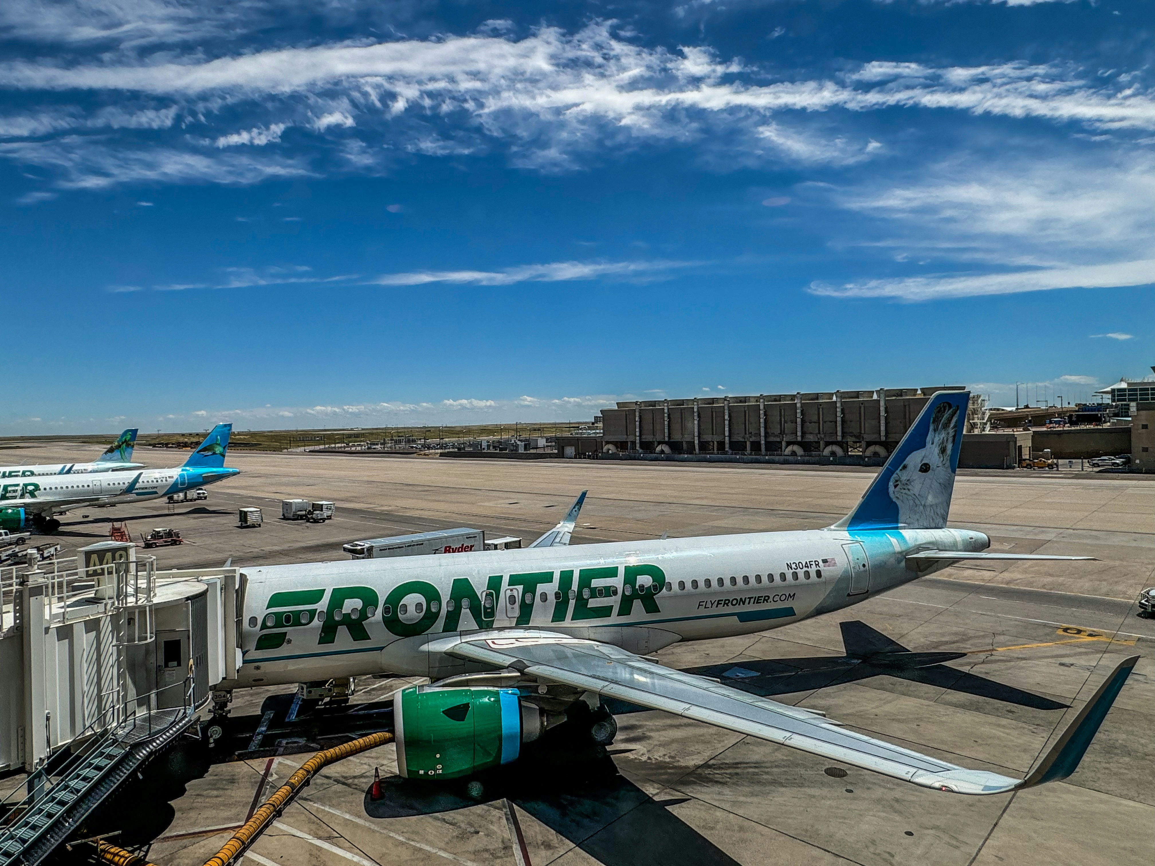 A frontier airplane parked on the tarmac at an airport