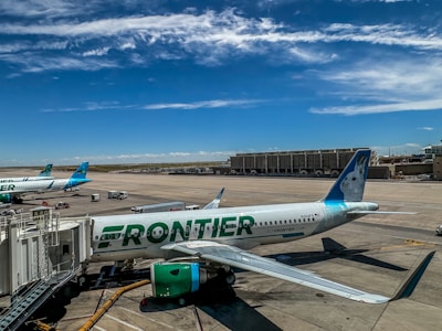 A frontier airplane parked on the tarmac at an airport