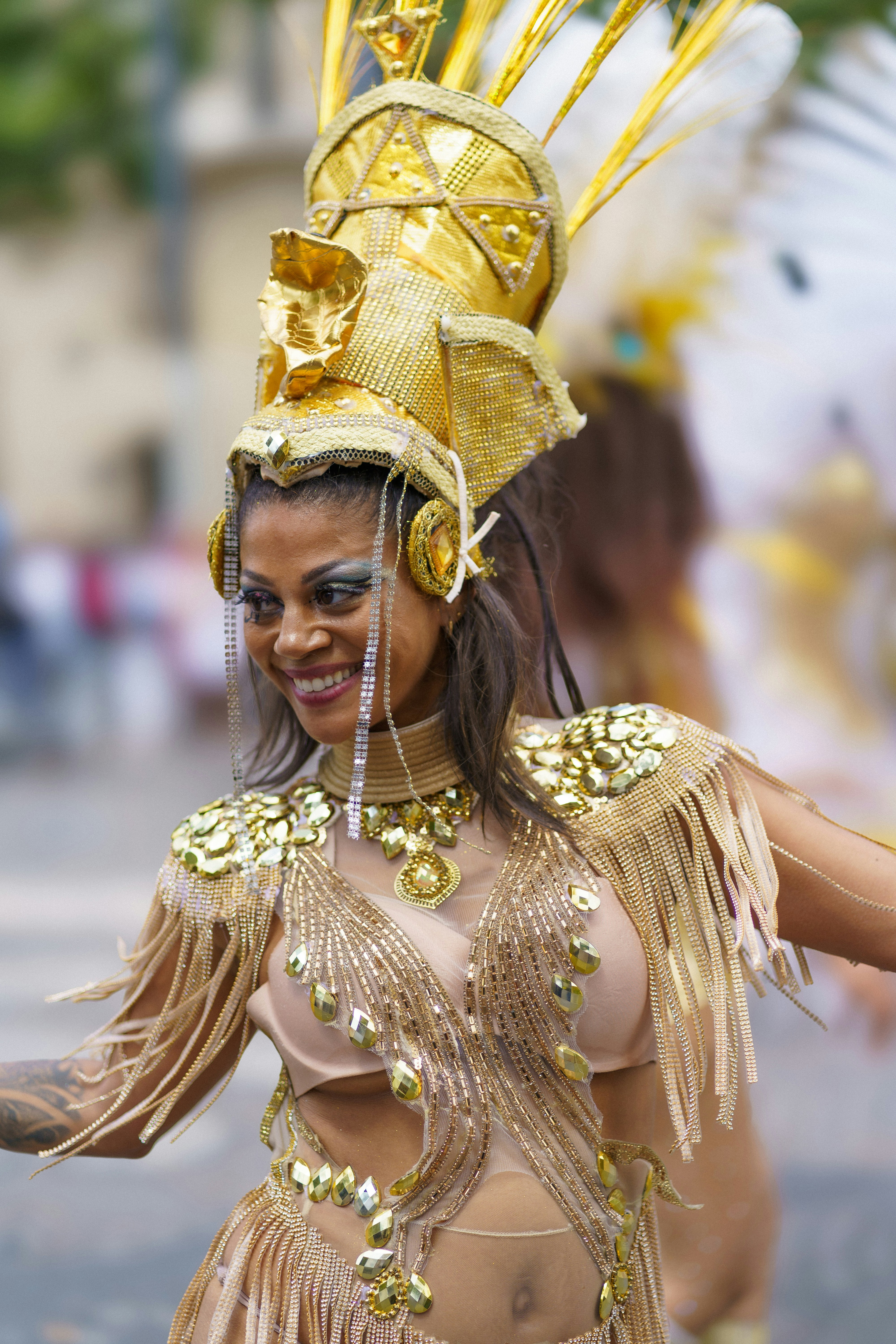 A woman in a gold costume dancing in the street