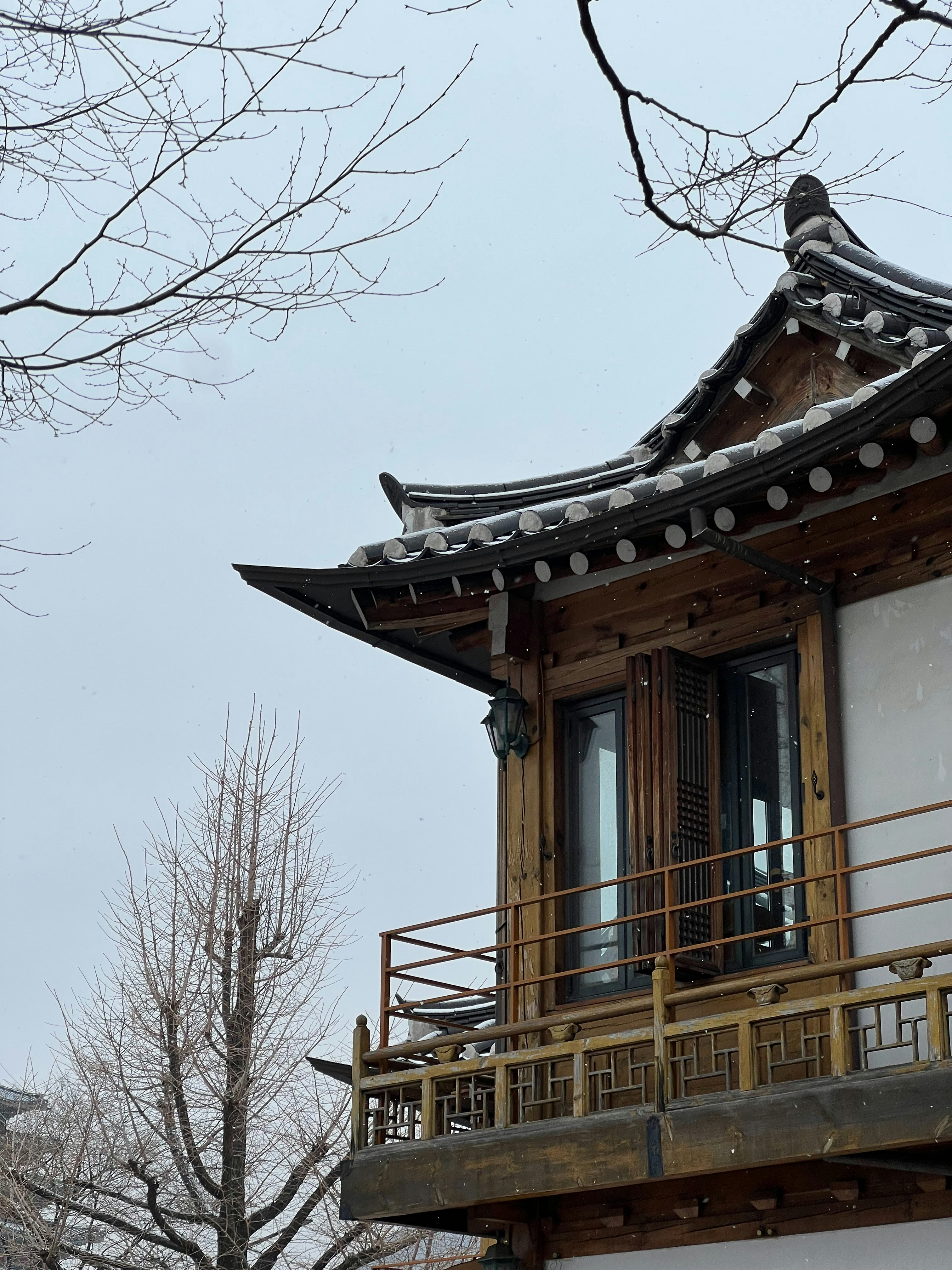 A tall building with a balcony and a clock on the top of it