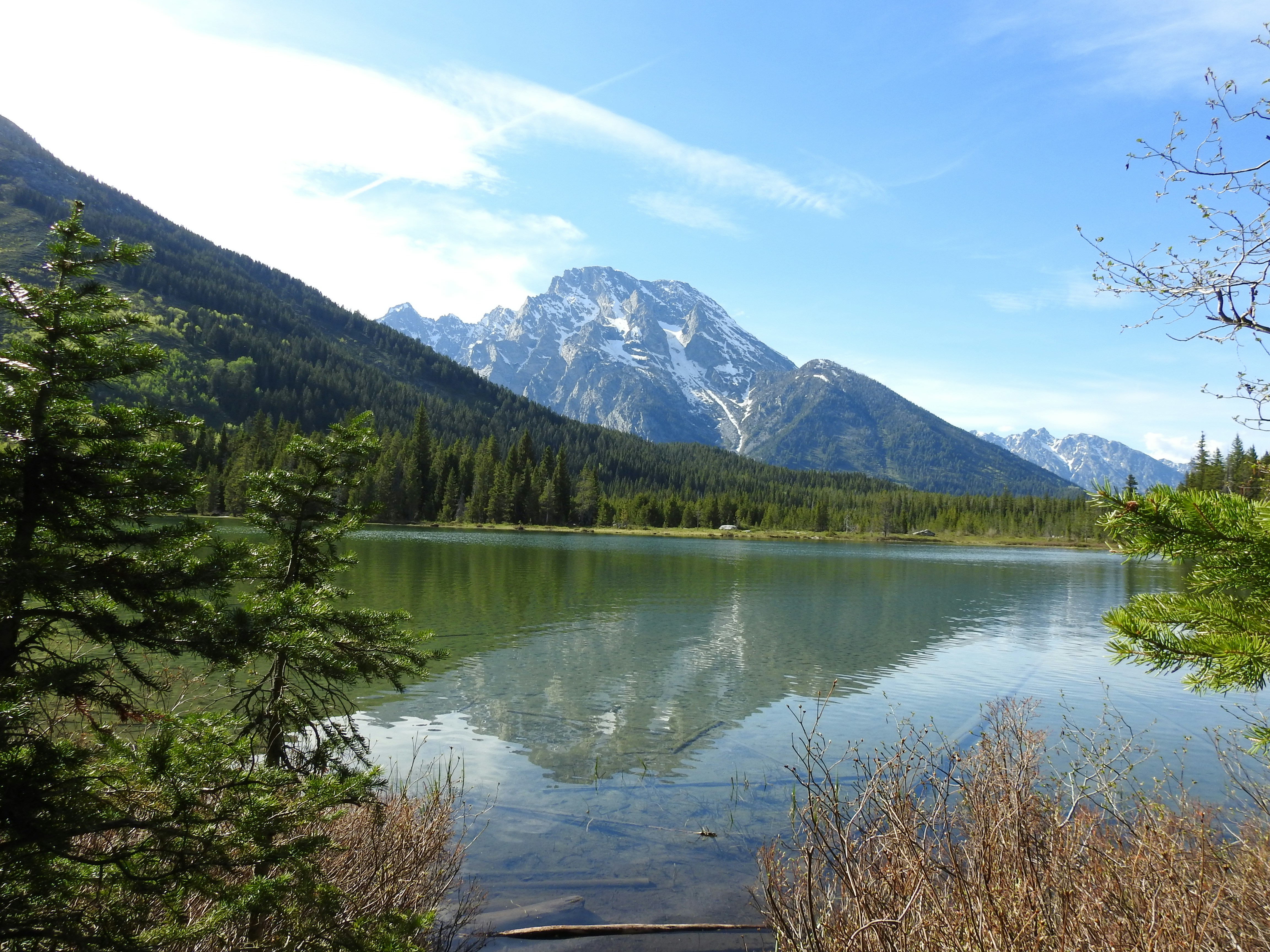 A body of water surrounded by trees and mountains