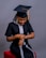 A woman sitting on a stool wearing a graduation cap and gown