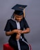 A woman sitting on a stool wearing a graduation cap and gown