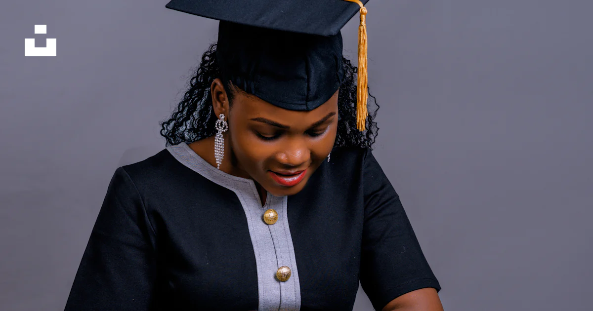 A woman sitting on a stool wearing a graduation cap and gown photo ...