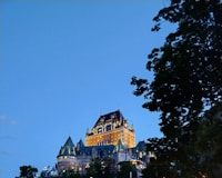 A castle lit up at night on top of a hill