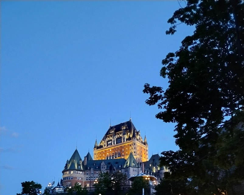 A castle lit up at night on top of a hill