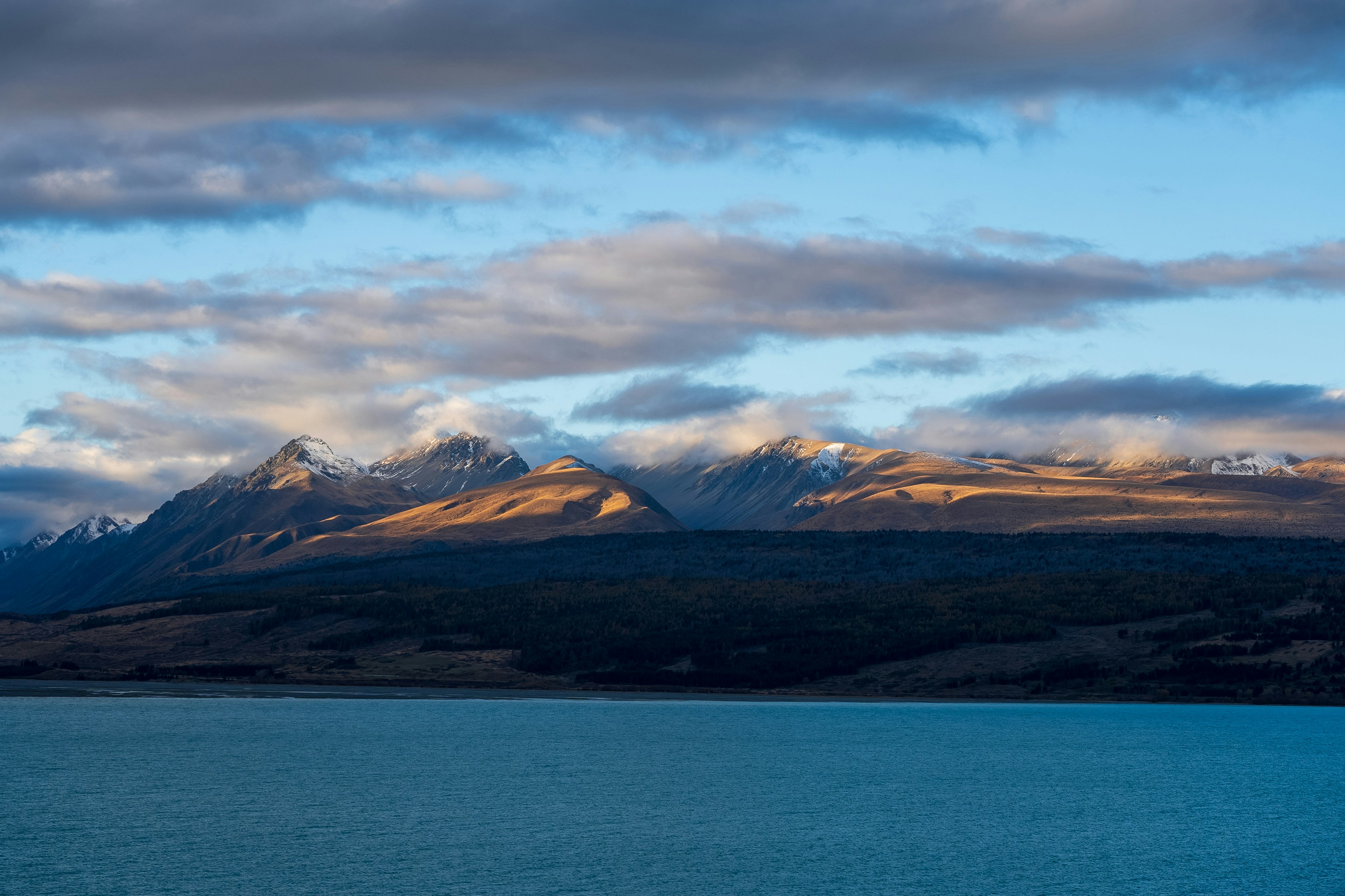 Ein großes Gewässer mit Bergen im Hintergrund