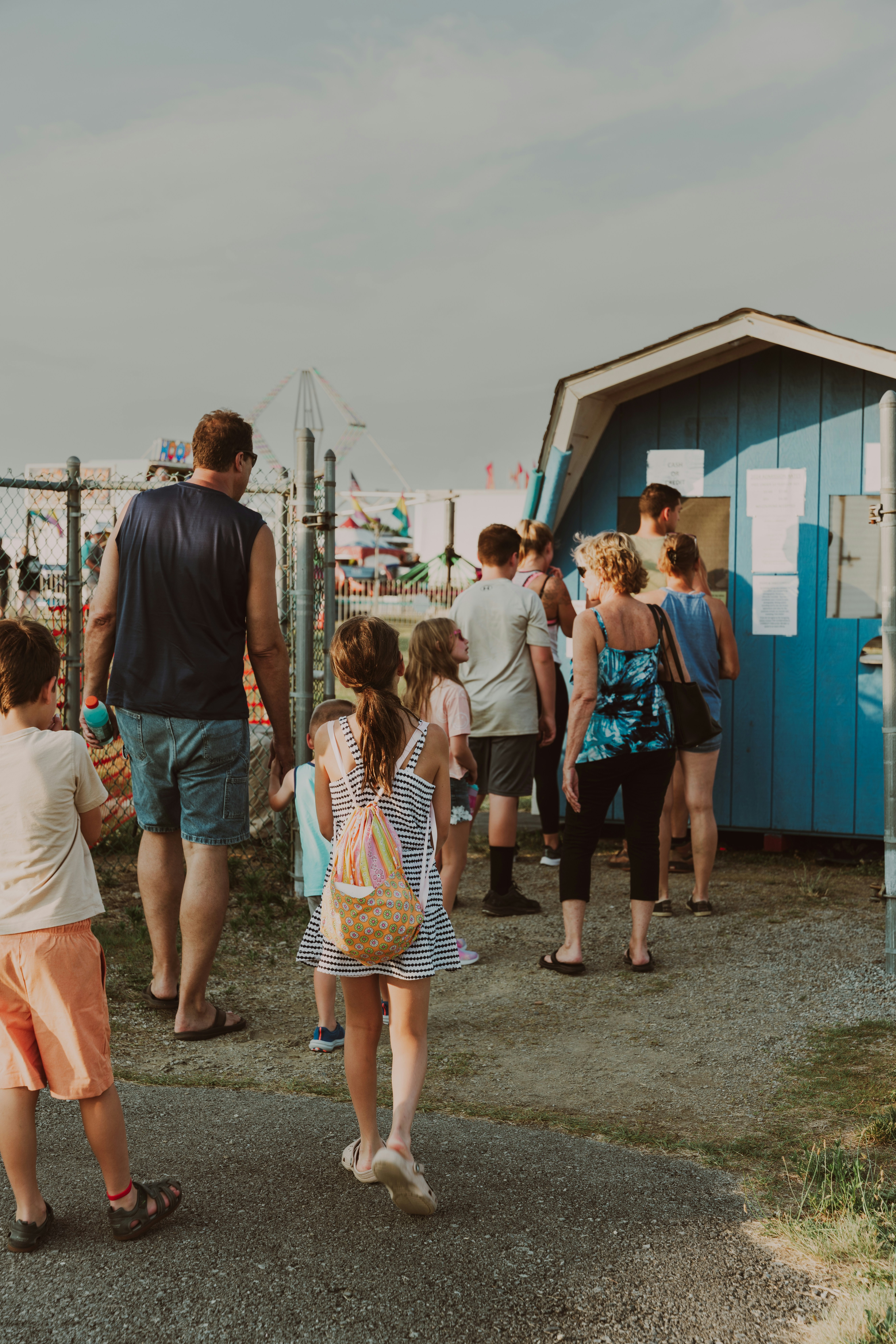 A group of people standing around a blue shack