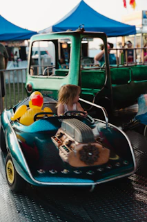 A little girl riding on a bumper car at a carnival