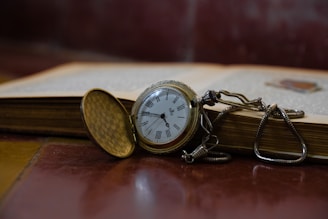 A pocket watch sitting on top of an open book