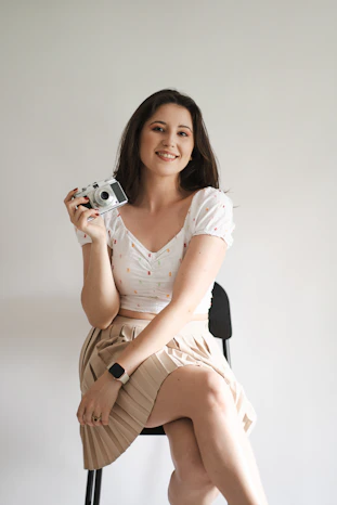 A woman sitting on a chair holding a camera