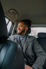 A man sitting in the back seat of a car