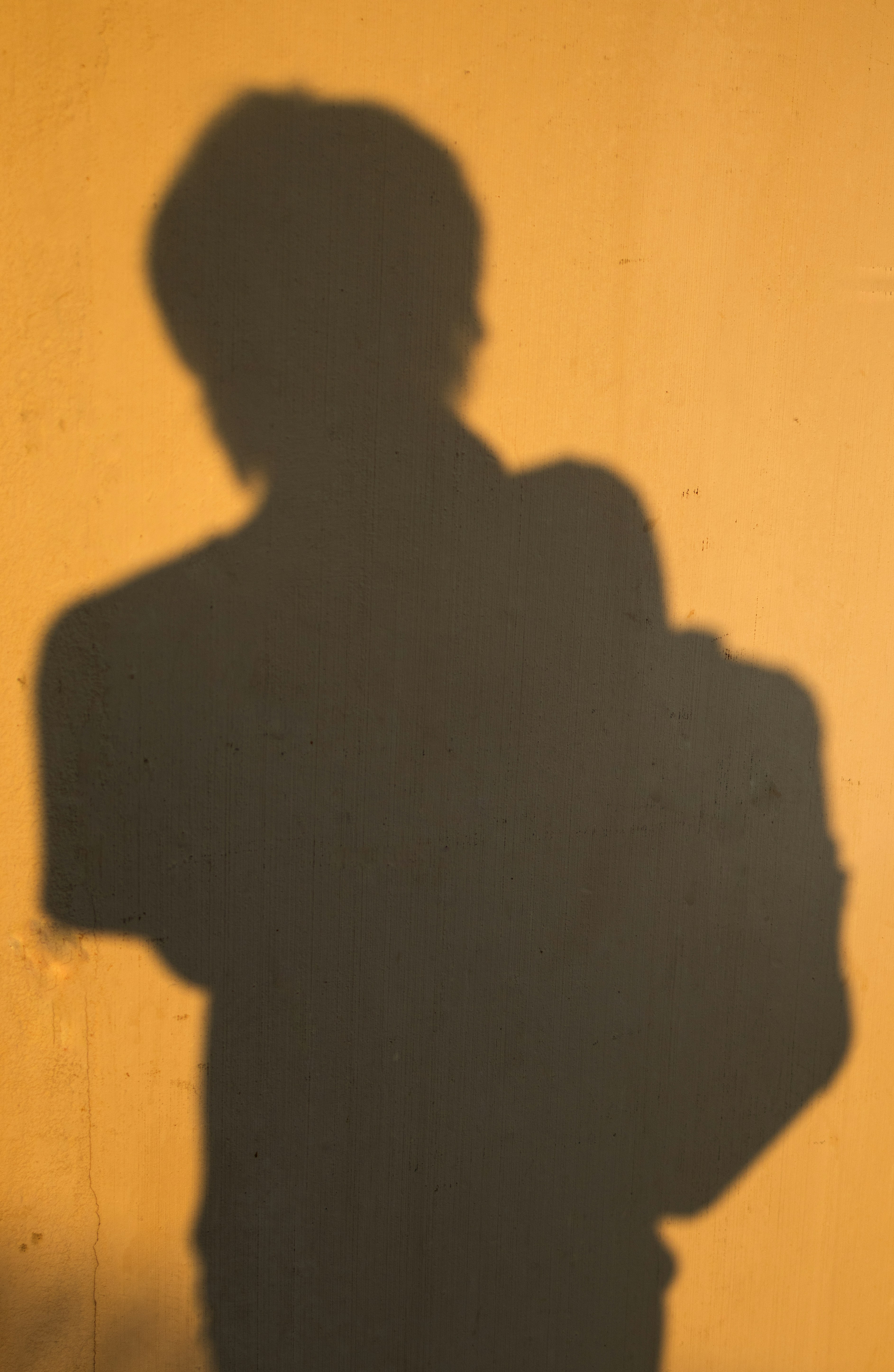 A shadow of a person standing in front of a wall