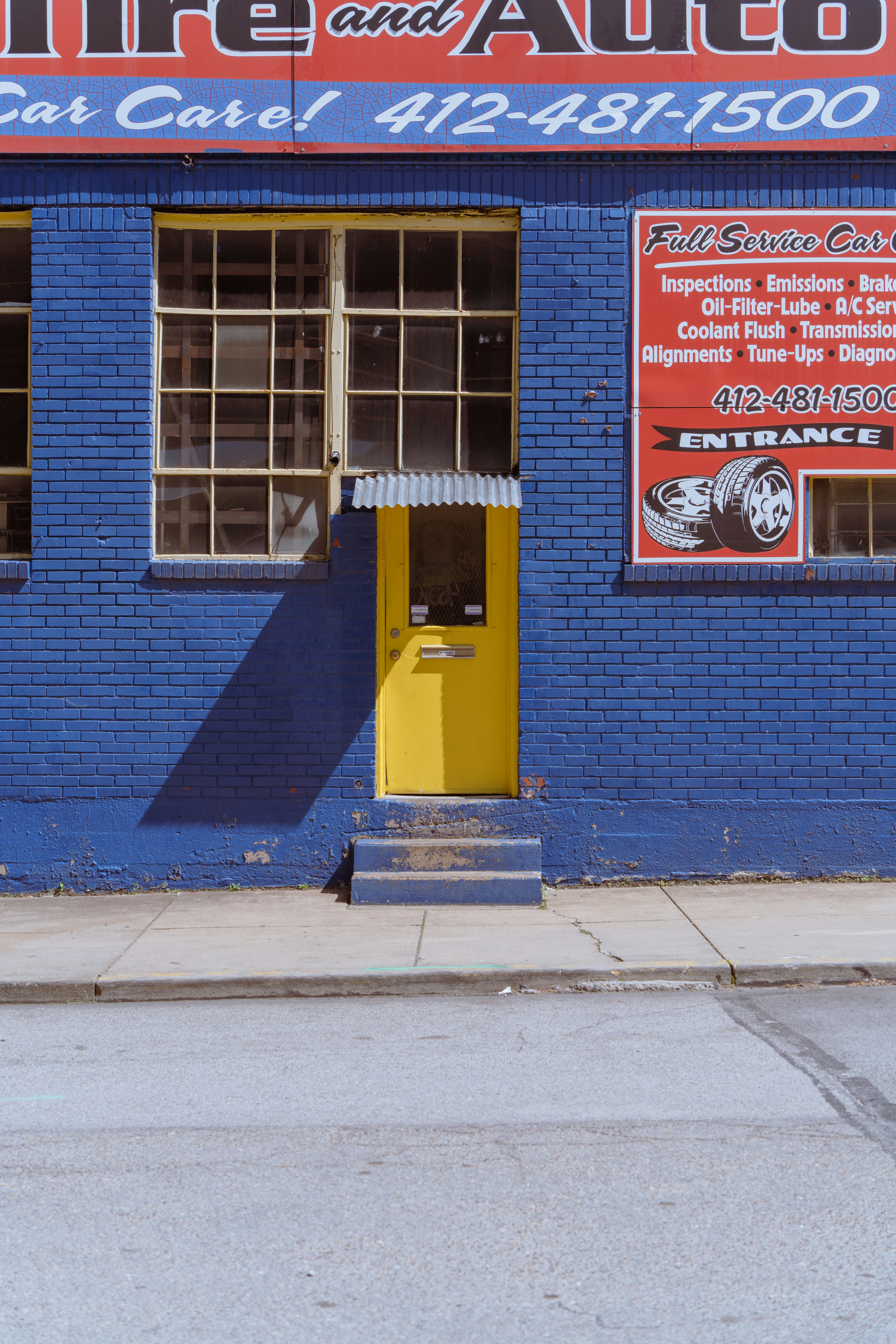 A blue and yellow building with a yellow fire hydrant in front of it