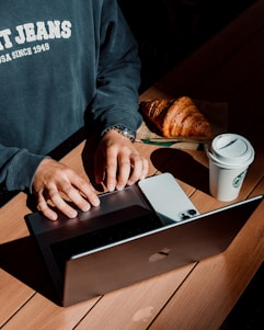 A man sitting at a table using a laptop computer