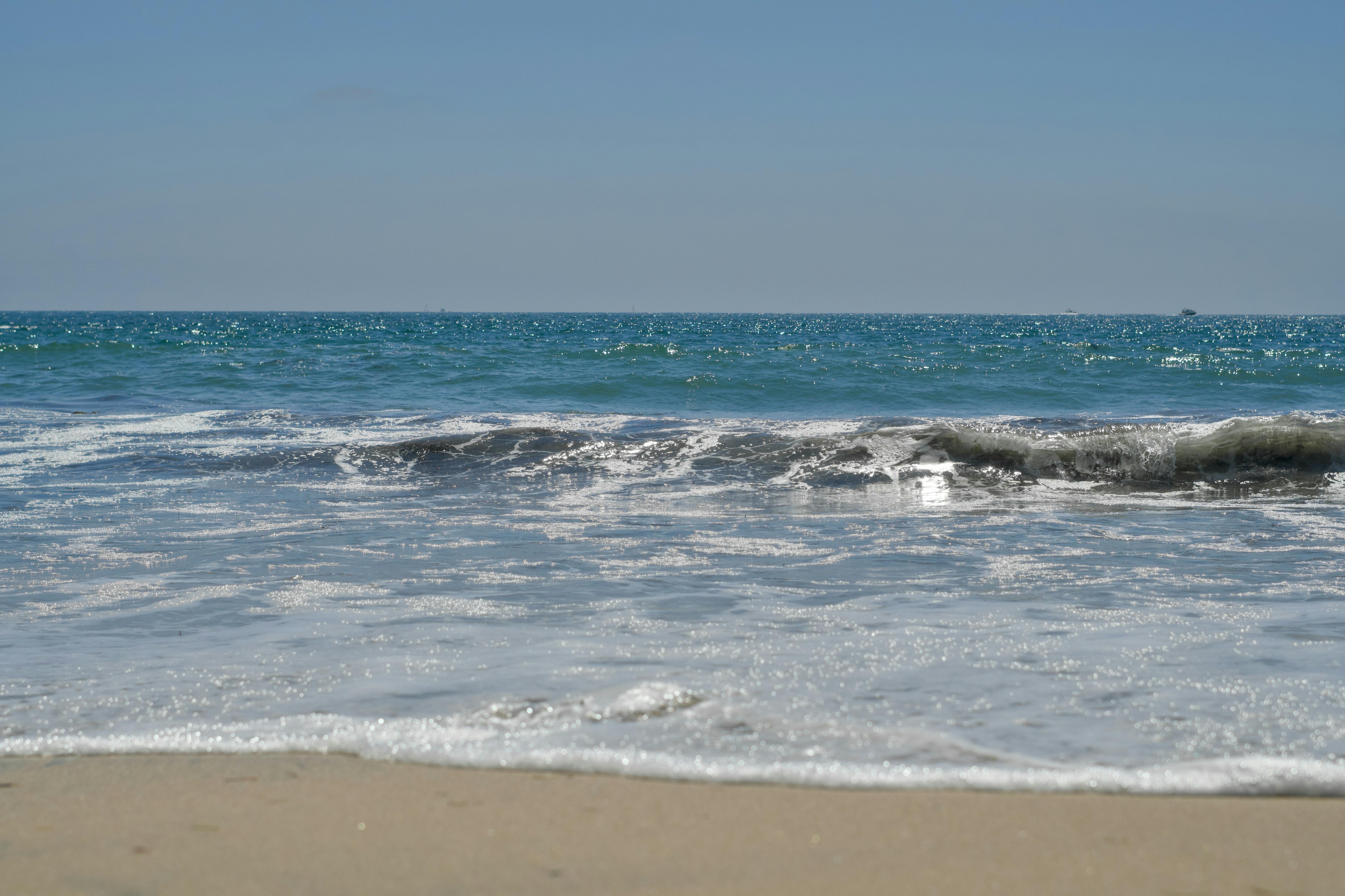A sandy beach with waves coming in to shore