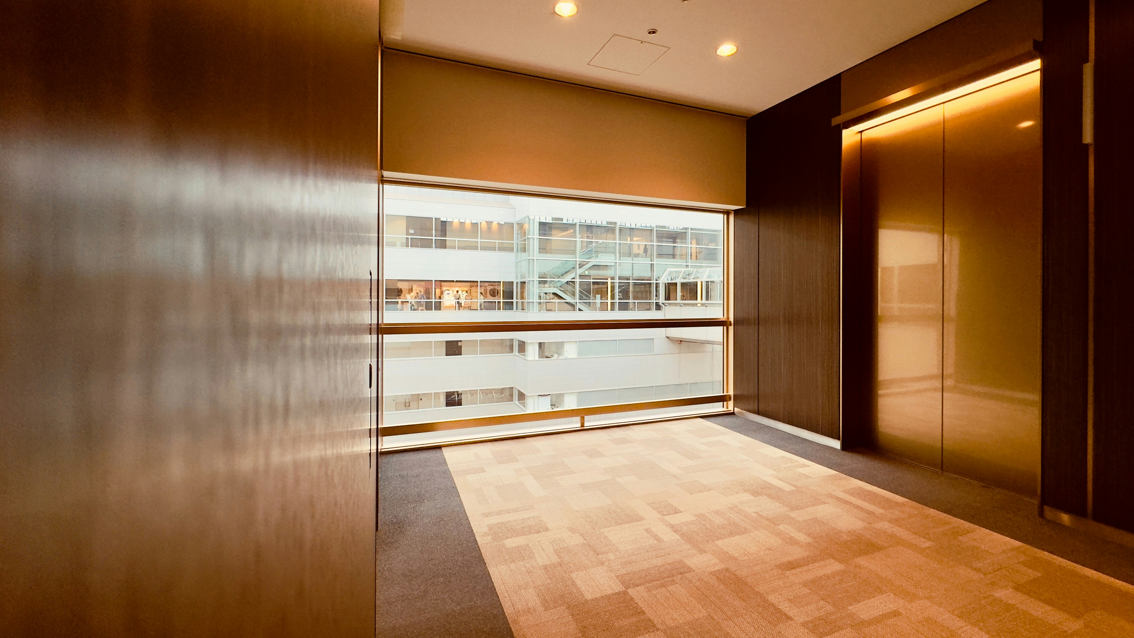 An empty room with wooden floors and a large window