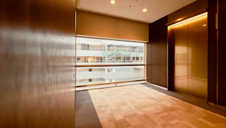An empty room with wooden floors and a large window