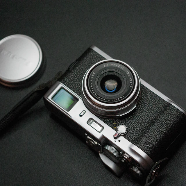 A compact camera and a pen lying on a table