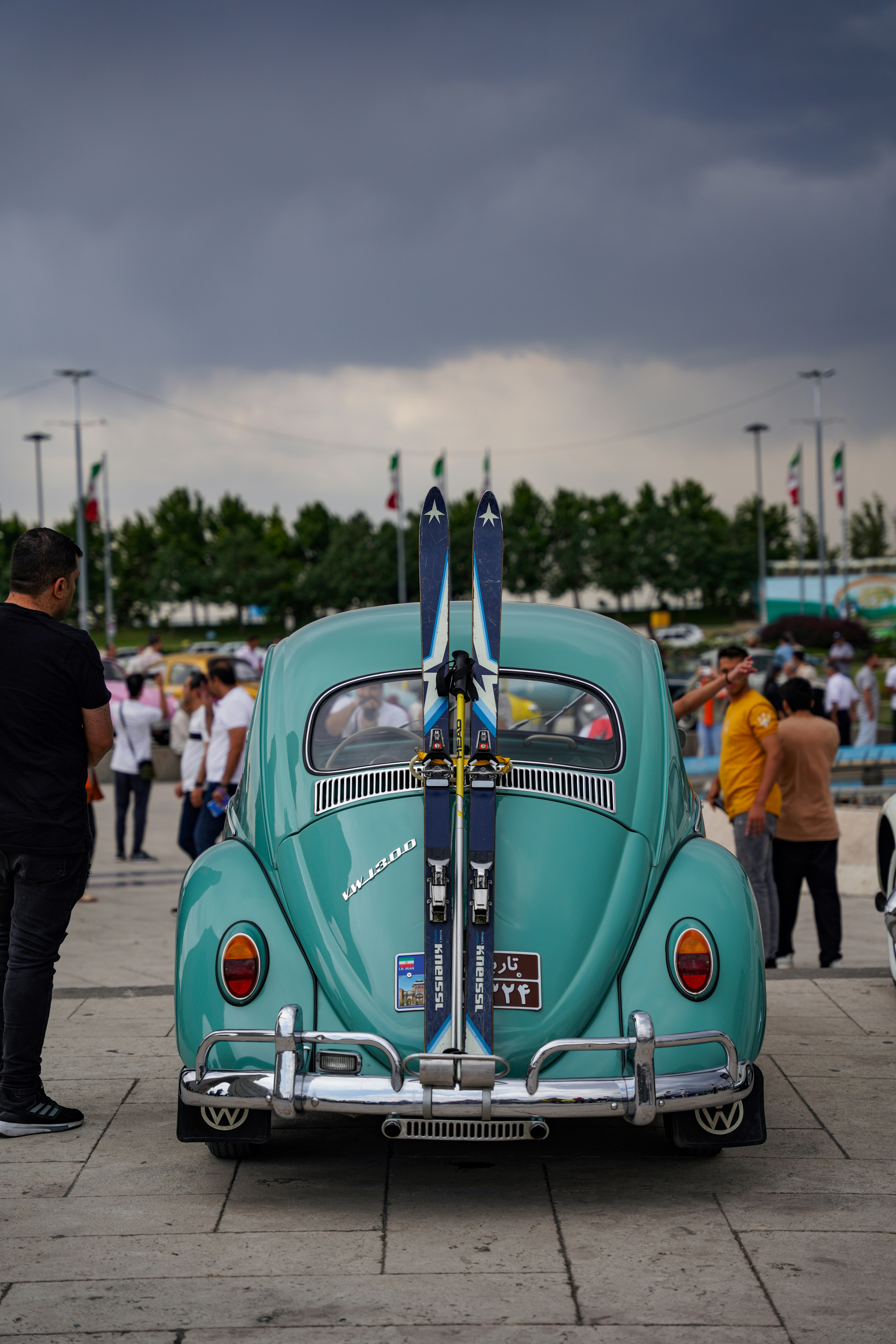 A blue car with a surfboard on the back of it