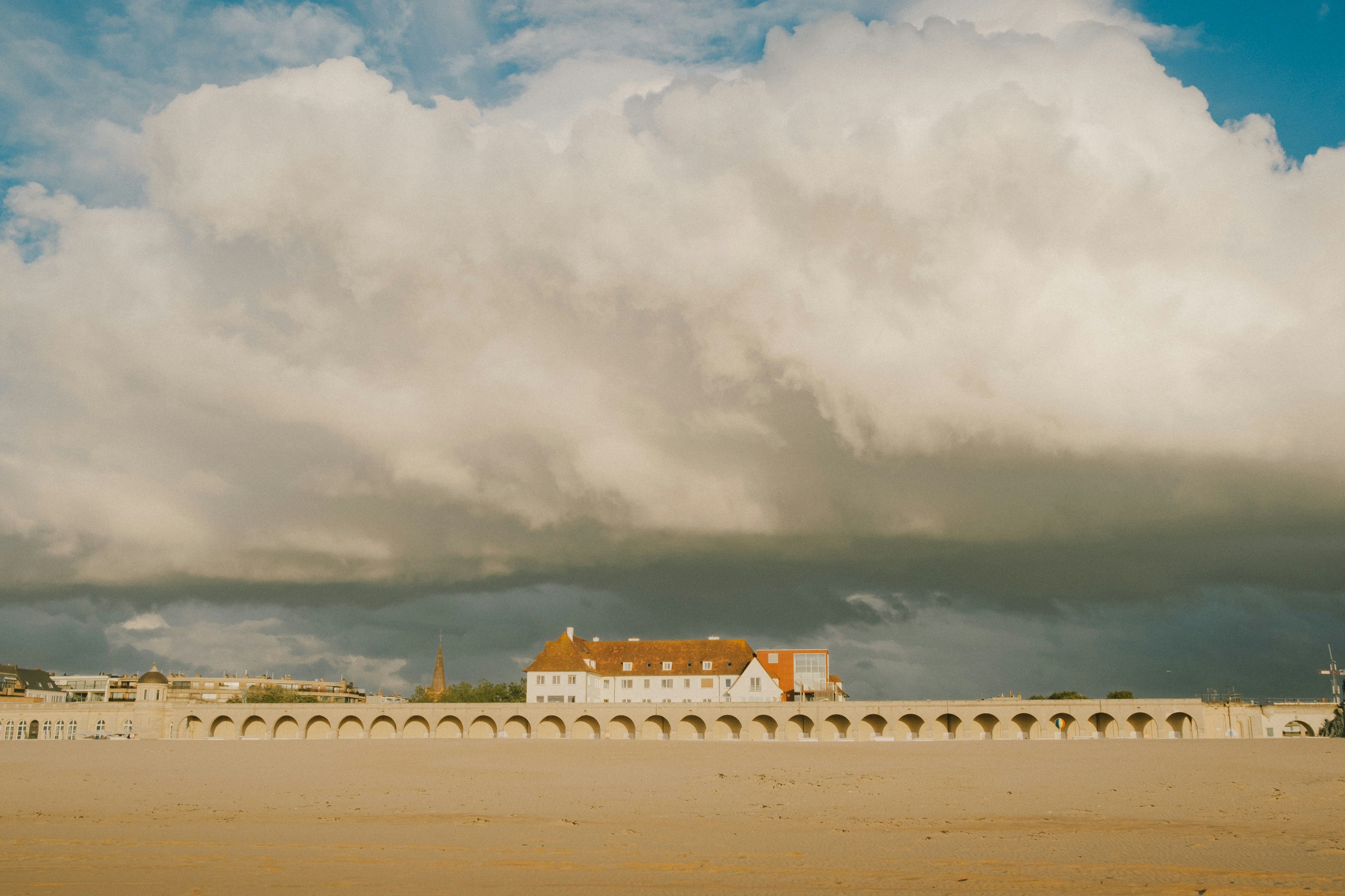 A large white building sitting on top of a sandy beach