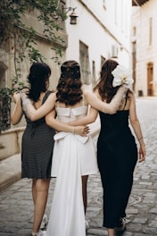 A group of women walking down a street next to each other